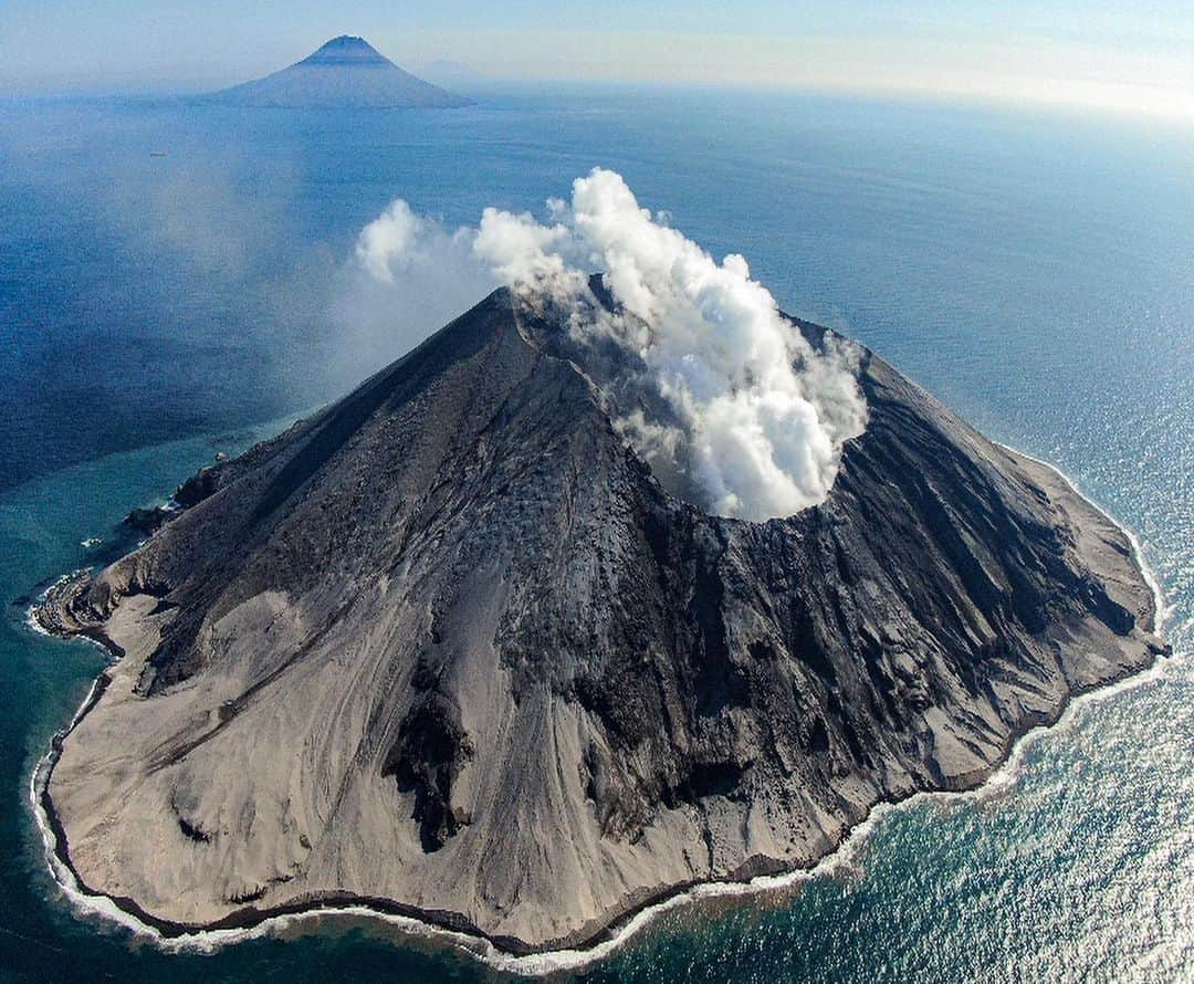 クリス・バーカードのインスタグラム：「I wrote down somewhere that one of my dreams in life has been to photograph an active volcano... I guess I have just seen so many beautiful images of them I figured it would be this transformative experience, but in reality it was actually really eye opening. . Yesterday we arrived at the newly erupted Raikoke island that had literally just exploded week ago. We were the first media team to document it. I had no clue that this island had mostly been cliffs before we arrived .. almost zero sandy beaches. We walked along virgin shores while steam rose through the sand & burnt the soles of our shoes. Ash in the air stung as it entered our lungs & eyes while we walking along what was once a completely green and lush island. (Google what it used to look like) What became very evident was that this volcano had destroyed any chance of life to continue to thrive on the island. Hundreds of thousand of displaced sea birds were in the sky & water with many dead on the beach. Vladimir our Russian scientist on board confirmed that the Sea Lion rookery had been wiped out leaving only a few stubborn males behind, his camera traps and observation hut also buried in ash. Dead seaweed from the changed ocean PH lined the rocks where we took samples of ash. It was altogether beautiful & terrifying. This photograph makes it appear as it has always looked this way but just weeks prior this island was vibrant green & it’s coastline was extremely different. For a deeper look check @taylorfreesolo ‘s post.  Shot on @djiglobal Mavic drone.  For more see @tomorrow_unlocked @renan_ozturk @rishisugla @jtkerby @povel」