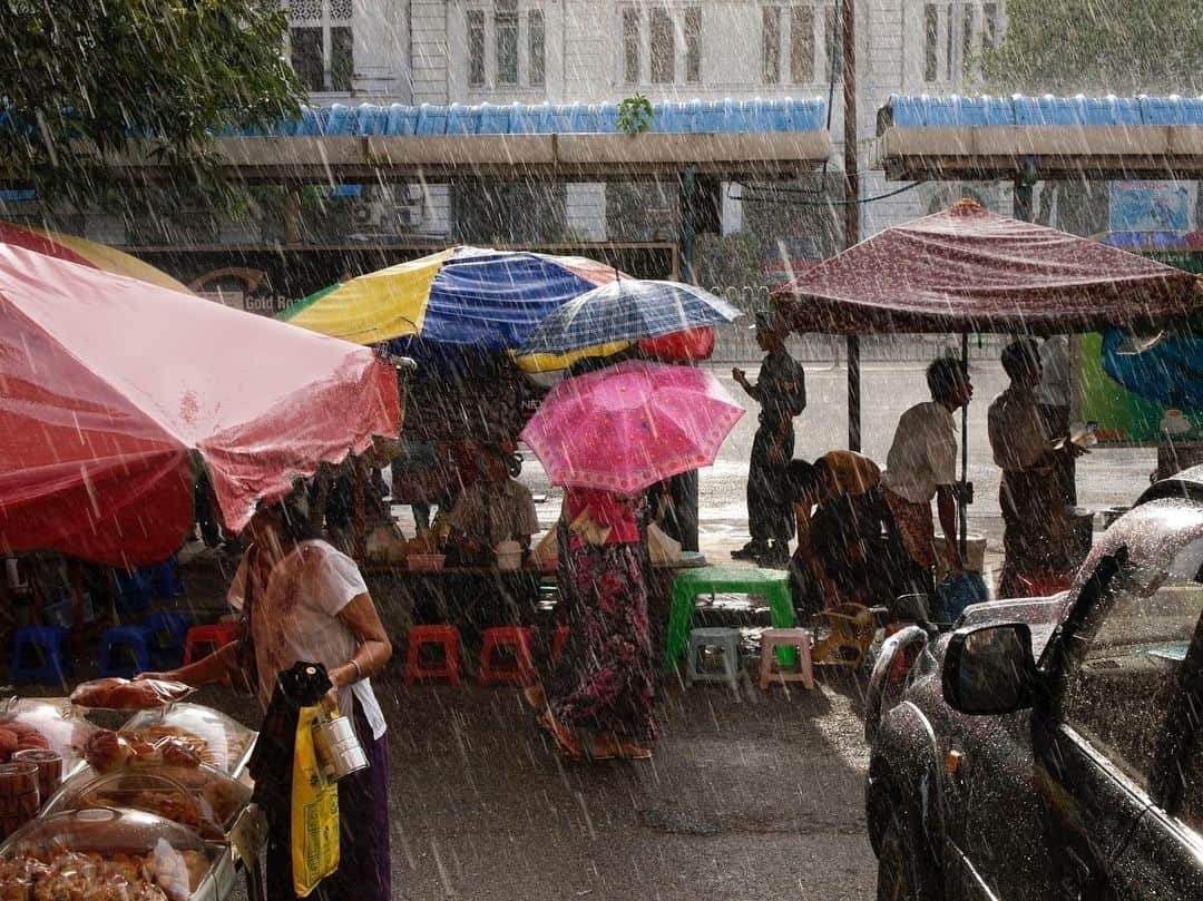 thephotosocietyさんのインスタグラム写真 - (thephotosocietyInstagram)「Photo by @chien_chi_chang // It was late on a May afternoon in the Burmese capital of Yangon. The air was hot and humid. One heavy gray cloud obscured the sun, and others sailed behind. Above each monolithic cloud, it seemed, there was a gigantic bucket of water at tipping point. In an instant, the bucket overflowed over downtown Yangon. The pedestrians and street vendors all reacted reflexively—finding refuge under colorful umbrellas, sheltering their wares, walking carefully around potholes of water in their sandals. While the rain continued to pour, the sun seeped through the clouds. A distant Buddhist chant provided a baseline to the cacophony of merchants, walkers, shoppers, and commuters. Then it was all over, business as usual, just another day during the rainy season. #MagnumPhotos #cccontheroad」7月15日 10時37分 - thephotosociety