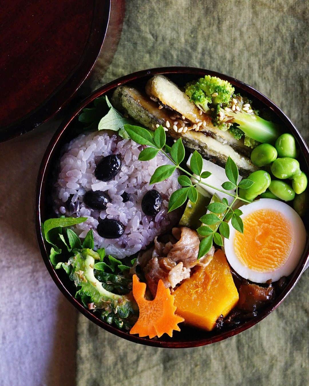Ryoko Yunokiのインスタグラム：「+ + + Black beans rice ball bento/黒豆ご飯のおにぎり弁当 . *black beans rice ball *fried mackerel with broccoli *bitter gourd salad with bonito flakes *soy-glazed beef *dashi-simmered squash *hard-boiled egg *edamame *soy-glaze shiitake mushrooms . ＊黒豆ご飯のおにぎり ＊鯵フライ ＊ゴーヤのお浸し ＊牛肉の時雨煮 ＊南瓜の出汁煮 ＊枝豆 ＊ゆで卵 ＊椎茸の佃煮 . . Bitter gourd salad - sliced bitter gourd is combined with soy sauce and bonito flakes + + + #bento #お弁当 #丸の内弁当 #f52grams #曲げわっぱ #井川メンパ」
