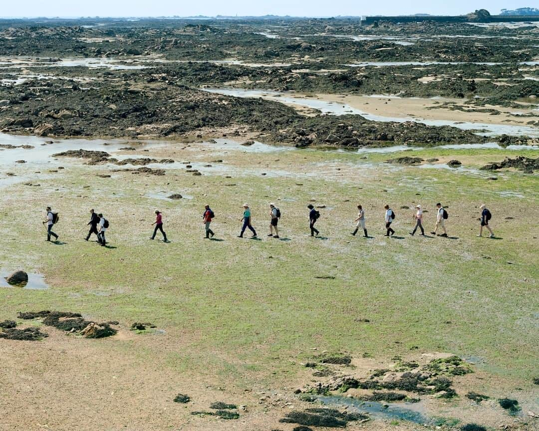 National Geographic Travelさんのインスタグラム写真 - (National Geographic TravelInstagram)「Photo by Gabriele Galimberti @gabrielegalimbertiphoto and Paolo Woods @paolowoods | Trudie Hairon, a guide with Jersey Walk Adventures, leads a group of tourists for a “Moonwalk” on a patch of seabed that can only be explored at low tide. The British crown dependency of Jersey experiences tides of up to ten meters, some of the world’s most dramatic, exposing kilometers of land that are covered by the ocean the rest of the time. #jersey #tide #moonwalk」6月23日 7時03分 - natgeotravel