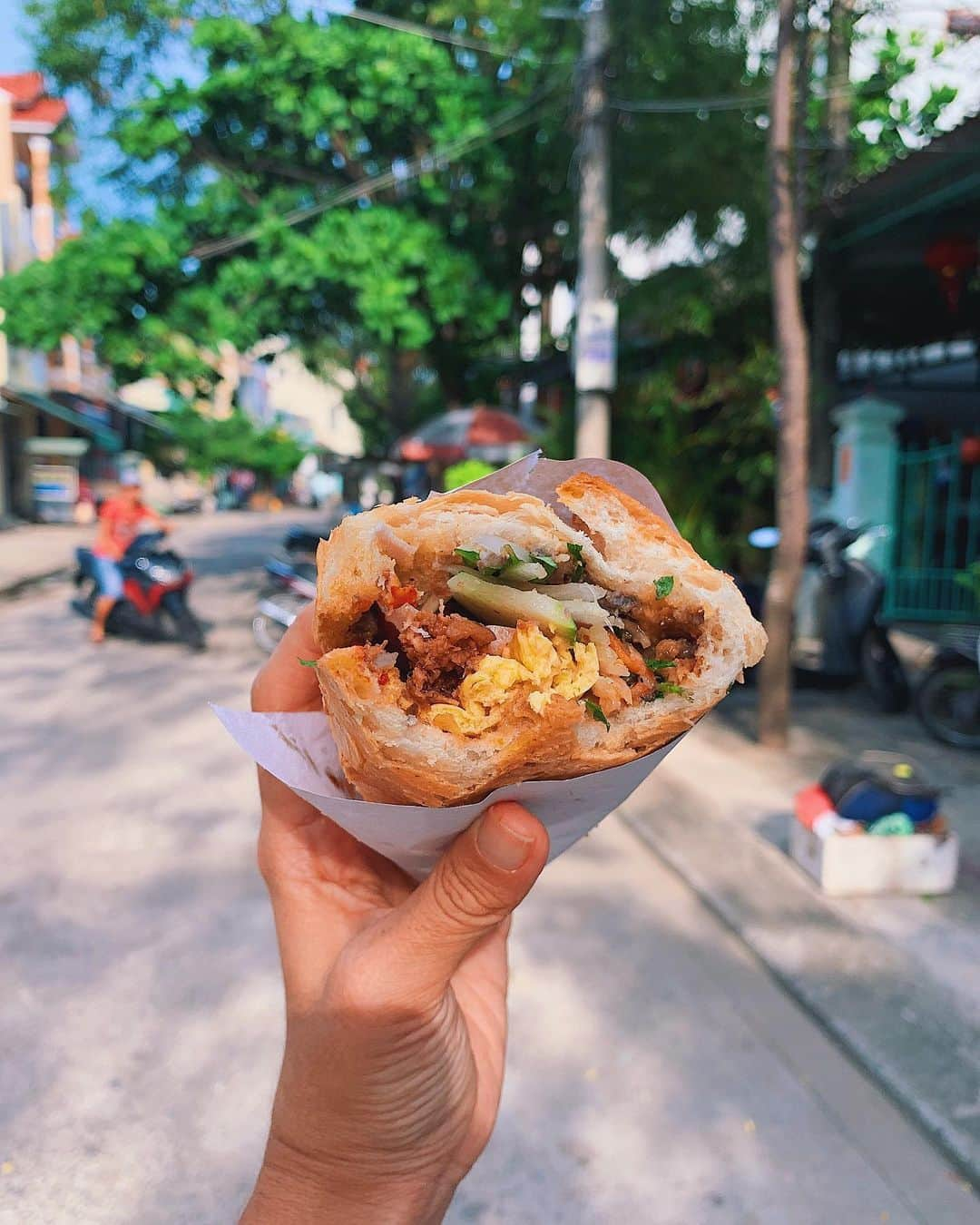 Girleatworldのインスタグラム：「🥖 Throwback to the one food that stood out the most while I was in Hoi An. I ate plenty of other stuff too (you can find my Hoi An food blog in the profile above ⏫). But this Banh Mi Thap Cam from Banh Mi Madam Khanh? No shame, ate it literally everyday for breakfast.  It's a crime to visit Vietnam and not have any Banh Mi. Banh Mi is a Vietnamese-style sandwich with various fillings – minced meat, liver pate, and fresh vegetables like lettuce, cucumbers, and pickled carrots. What's interesting about Banh Mi is that the bread is very similar to the French baguette – strong evidence of French influence on the region during the colonial period. However, unlike baguette which tends to be long, Banh Mi is noticeably shorter and fits just right in your hands.  You'll hear the word "Banh" used a lot in Vietnamese food, and you might wonder why. Apparently, "Banh" is used to describe anything made from flour! The word "Banh Mi" itself in Vietnamese actually just means "bread". So, you cannot just order Banh Mi – you’d just be ordering bread.  There are different types of Bahn Mi – sometimes with chicken, with vegetables, or a combination of meat and vegetables. My favorite is Bánh Mì Thập Cẩm, which is the combination bread – it's got a little bit of everything! I loved the contrasting textures on each bite. The bread that is crunchy outside yet soft inside, the juicy meat, and then the combination of fresh and pickled vegetables.  #girleatworld #shotoniphone #banhmi #banhmiqueen #hoian #hoianfood #vietnam #vietnamesefood #🥖 #vietnam🇻🇳」