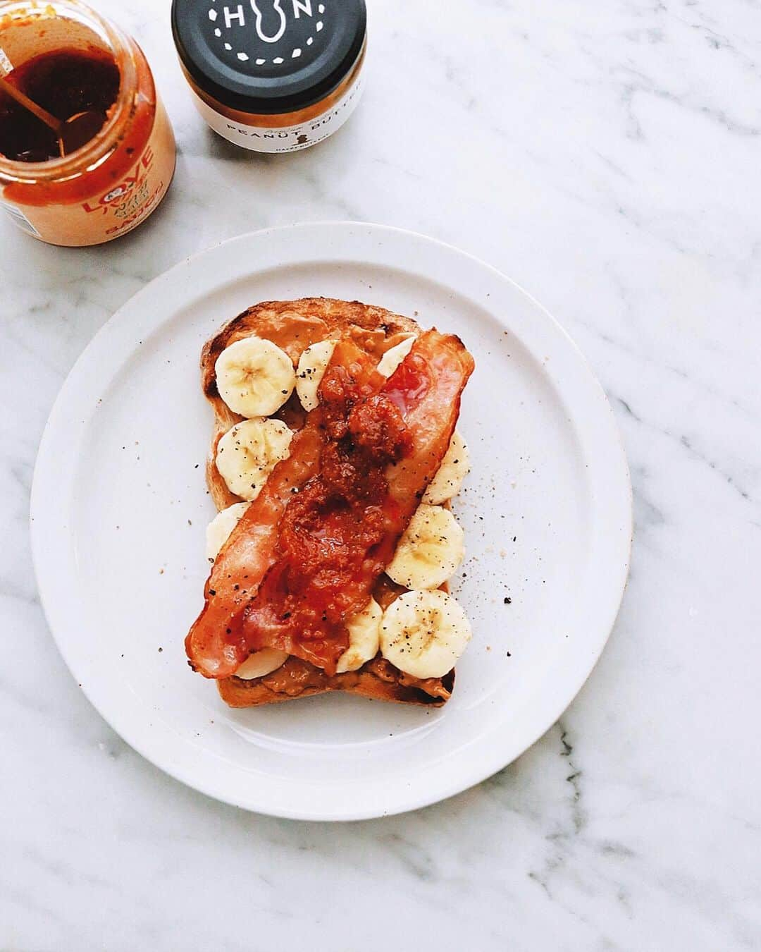 樋口正樹さんのインスタグラム写真 - (樋口正樹Instagram)「Elvis Sandwich . 今朝はエルビスサンド。 網焼きしたトーストに、 ピーナッツバター塗り、 バナナのスライス並べ、 焼いたベーコンのせる。 そして、 ここから少し味を変え、 さらにラブパクを塗り、 胡麻油まわしかけたら 仕上げに黒胡椒をふる。 濃厚な担々麺みたいに とても強く個性を増し、 寝ぼけ頭も覚める味に⁉︎ . 👉@happynutsday 👉@lovepakcheesauce この２つの組み合わせ かなりのパンチですよ。 辣油と酢を足すのも◎。 . . #elvissandwich #オープンサンド #エルビスサンド #エルヴィスサンド #ハッピーナッツデイ #ピーナッツバター #ラブパク食堂 #ラブパクチーソース #朝バナナ#lovepakcheesauce #happynutsday」6月25日 7時22分 - higuccini