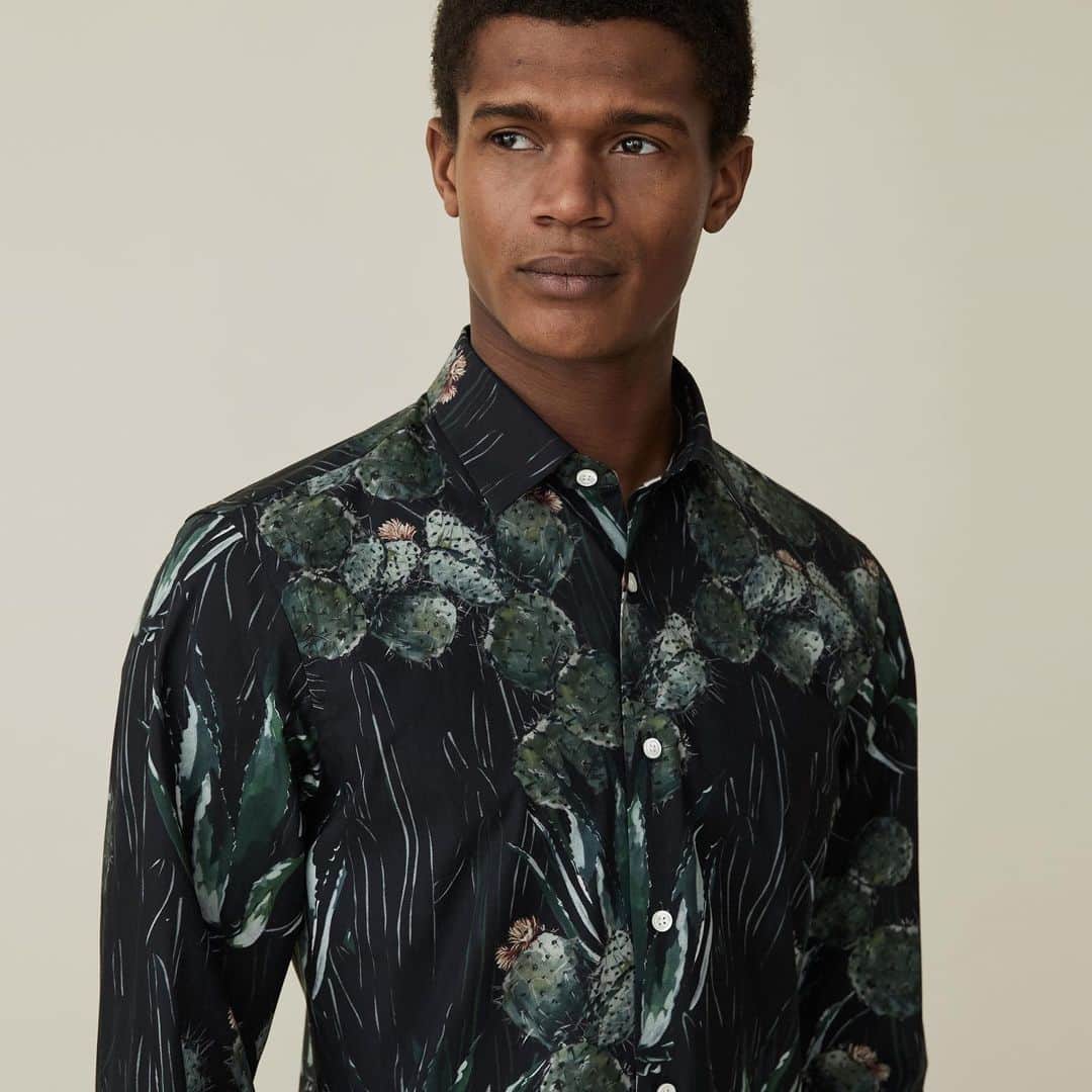 ギーブス&ホークスのインスタグラム：「This dark green casual shirt features a chic cactus print, referencing this collection’s botanical inspiration. It’s cut with a casual fit, classic spread collar and single cuffs. Try it beneath a dark suit to make a sophisticated statement this season, or pair with our slim fit chinos for an alfresco dinner during the warmer months.」