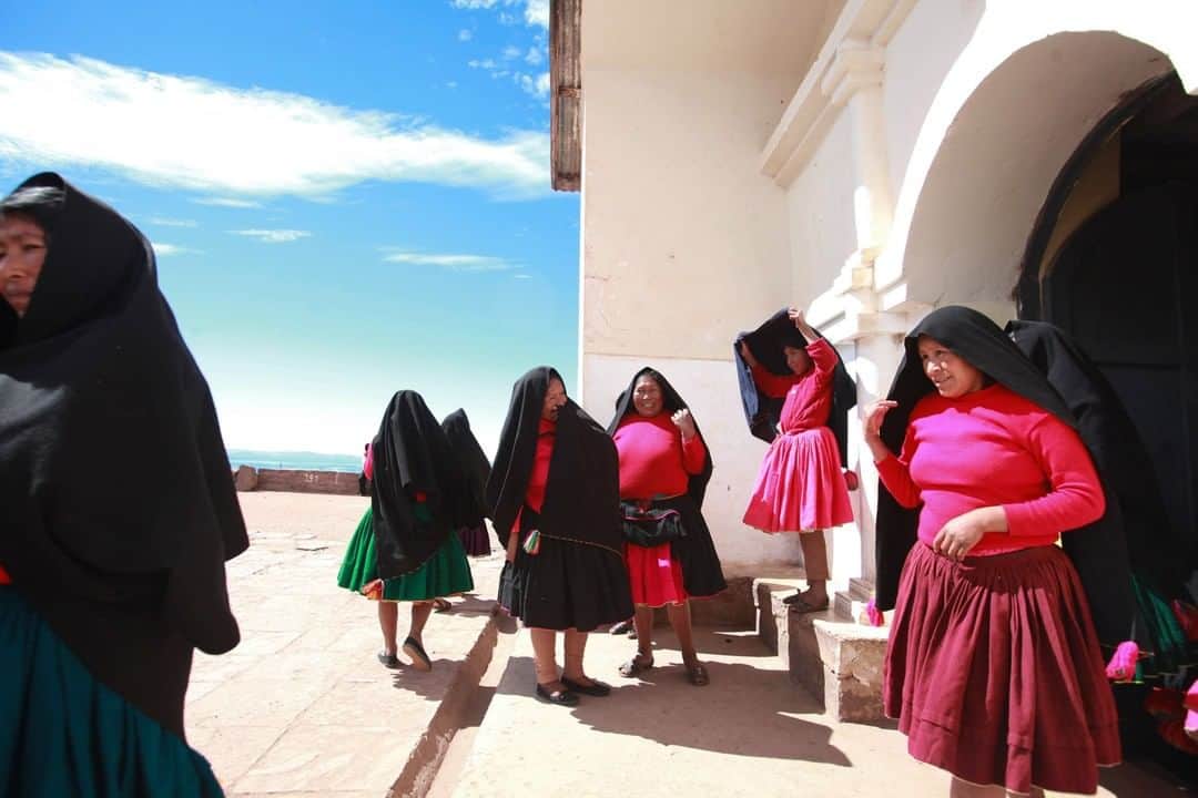 National Geographic Travelさんのインスタグラム写真 - (National Geographic TravelInstagram)「Photo by @sofia_jaramillo5 | Women wait outside a church during a wedding ceremony on the island of Taquile on Lake Titicaca in Peru. The traditional dress for women of this island consists of red or pink outfits and a black scarf. The scarves have colorful yarn balls on each corner, which can be used to answer marriage proposals or signify mood. For more photos from Peru and South America, follow me, @Sofia_Jaramillo5. #southamerica #Peru」6月25日 19時00分 - natgeotravel