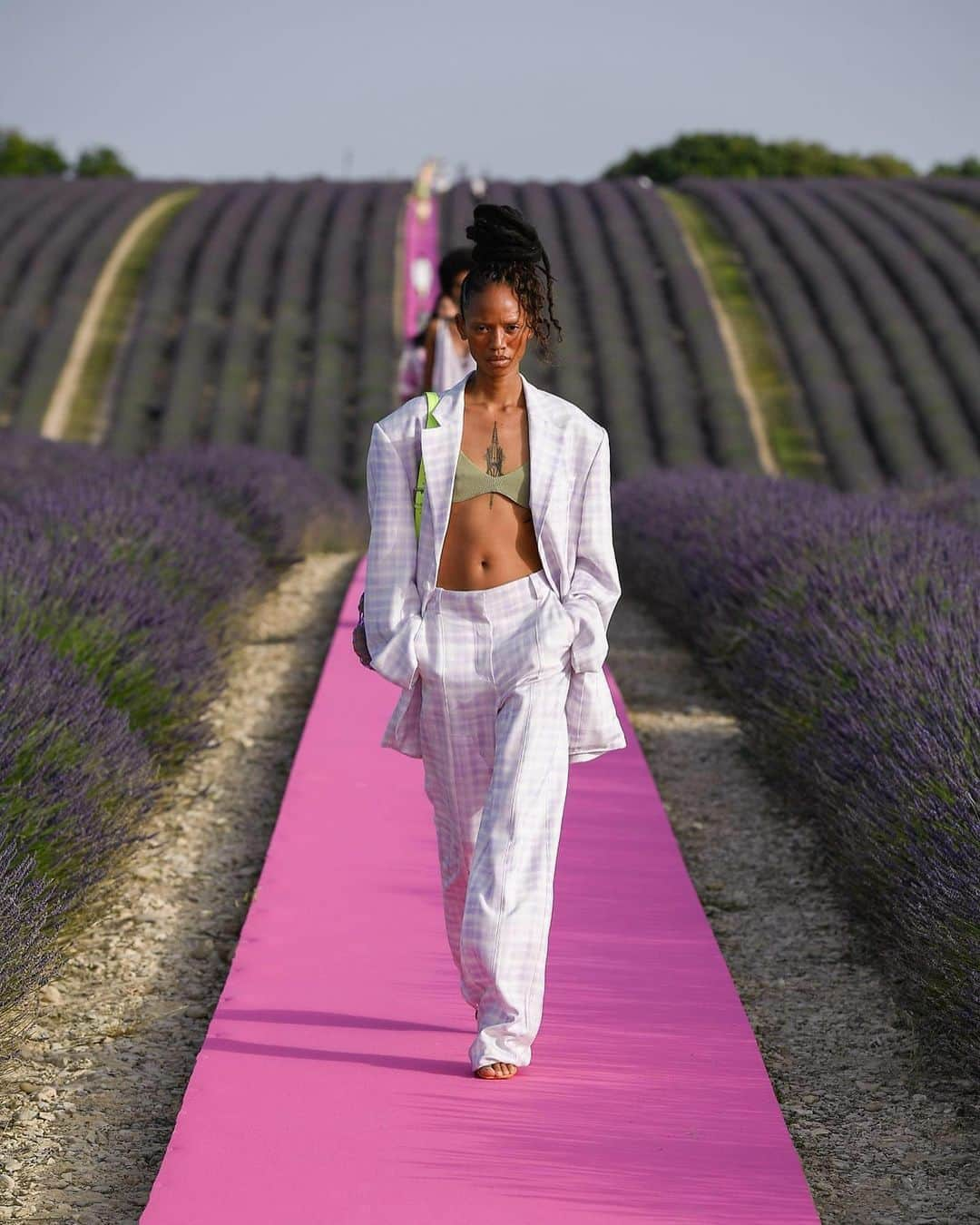 Fashion Weekさんのインスタグラム写真 - (Fashion WeekInstagram)「Lavender fields, forever. @Jacquemus celebrated their 10 year anniversary on the designer's home soil in France. Models breezed down an electric pink runway surrounded by lavender in breezy dresses and tailored suits in bright hues. 👈 For perfect Summer looks.」6月26日 5時05分 - fashionweek