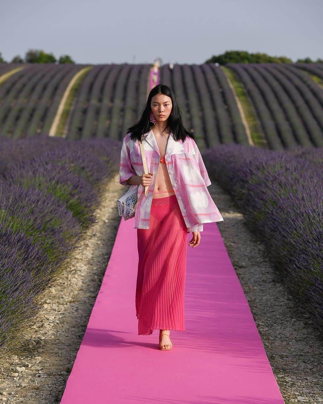 Fashion Weekさんのインスタグラム写真 - (Fashion WeekInstagram)「Lavender fields, forever. @Jacquemus celebrated their 10 year anniversary on the designer's home soil in France. Models breezed down an electric pink runway surrounded by lavender in breezy dresses and tailored suits in bright hues. 👈 For perfect Summer looks.」6月26日 5時05分 - fashionweek