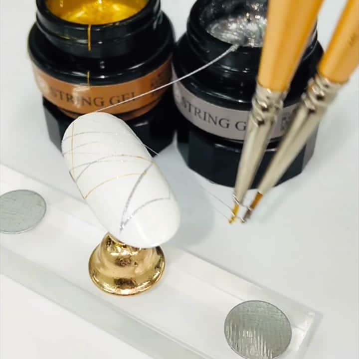 のインスタグラム：「🌟6月発売🌟 SIMPLY ストリングジェル❤️ . このストリングジェルは、伸びがよく、弦のように繊細なアートを描くことができます❗ . ラメの密度が濃いので細い線でも存在感が出て繊細に輝きます。 . 粘度にもこだわって開発されているため、簡単な操作で太い線も細い線も自由に描けます🎉 . トルコアイスの様にびよ～んと伸びて、シルクの糸のように煌きます✨ . 爪の上下をぐるりと回るように筆を動かすのがおススメ🌟 . 筆をゆっくり大きめに動かすとストリング状に美しく伸びますよ❗ . アートが楽しくなる素敵なジェル、ぜひ取り入れてみてください❤️ . . #SIMPLY #シンプリー #ストリングジェル . #rednails #レッドネイルズ #ネイル #ネイルアート #ジェルネイル #セルフネイル #nails #nailart #naildesigns #gelnails #japanesenail #kawaii #美甲 #指甲 #批发 #네일숍 #도매상 #네일아트」
