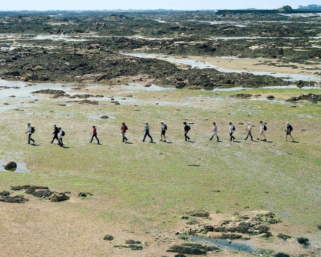 thephotosocietyさんのインスタグラム写真 - (thephotosocietyInstagram)「Photo by Gabriele Galimberti @gabrielegalimbertiphoto and Paolo Woods @paolowoods / Trudie Hairon, a guide with Jersey Walk Adventures, leads a group of tourists for a “Moonwalk,” on a patch of seabed that can only be explored at low tide. The British crown dependency of Jersey experiences tides of up to ten meters, some of the world’s most dramatic, exposing kilometers of land that are covered by the ocean the rest of the time. Jersey #jersey #tide #moonwalk」6月26日 21時42分 - thephotosociety