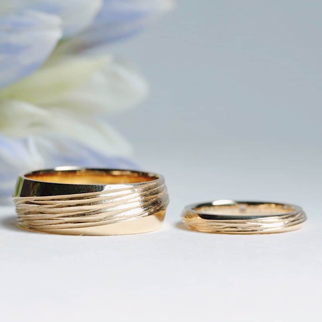 ith / イズ オーダメイド結婚指輪さんのインスタグラム写真 - (ith / イズ オーダメイド結婚指輪Instagram)「🌳樹皮のような模様を指輪に . 二面が入れ替わる デザインを活かして、 樹皮の彫り模様と光沢面を組み合わせ 結婚指輪をお仕立てしました。 . 男性の指輪は、《アレグロ》を 大胆に幅を太くしてアレンジ。 . 女性とお揃いのデザインなのに、 雰囲気が全く違って見えます。 . ペア感と個性の両方が感じられますね。 . . 結婚指輪：Allegro《アレグロ》 参考価格(K18/男性)：115,000円〜 . . 結婚指輪：Allegro《アレグロ》 参考価格(K18/女性)：114,000円〜 . . ithの指輪を購入された方は  #イズマリッジ に投稿してください🤳 Instagram投稿フェア実施中🎁✨ . . @ith_marriage ←指輪の一覧はこちらからご覧いただけます💍 . . #結婚指輪 #婚約指輪 #プロポーズ #マリッジリング #エンゲージリング #指輪 #ダイヤモンド #ブライダルジュエリー #婚約 #プレ花嫁 #ペアリング #指輪選び #ウェディングドレス #ナチュラルウェディング #指輪探し #結婚指輪探し #ゴールドリング #オーダーメイドリング #結婚式準備 #結婚式 #結婚式場 #花嫁 #2019秋婚 #2019冬婚 #2020春婚 #令和婚 #一生もの」6月27日 12時10分 - ith_marriage