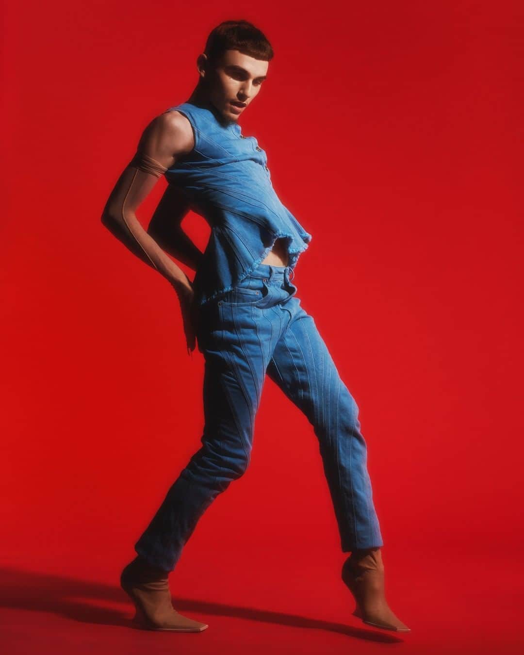 のインスタグラム：「Alex Duval, french dancer for the ballroom house of Miyake Mugler, based in Paris, for Mugler Resort 2020. - Alex wears a Mugler blue spiral denim top with matching trousers, nude nail ringsover nude sheer gloves and nude stretch nappa ankle boots. - Creative Director @cadwallader  Styling @alex_jordan_harrington  Photography @arnaudlajeunie  Casting @julialangecasting  Hair @jondefranc  Make up @christinecorbel  Movement @jordandrobson  Production @kitten_production  Model @whitemugler #mugler」