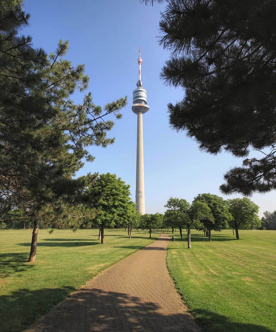 Wien | Viennaさんのインスタグラム写真 - (Wien | ViennaInstagram)「Another creative shot by @paperboyo! This time featuring the Donauturm - a 252 metre tower located near the Danube River. It is actually among the 75 tallest towers in the world. At the top one can find two rotating restaurants and the view from up there is simply stunning. Did you know this amazing sight? 🌳👀 by @paperboyo #ViennaNow」6月28日 1時00分 - viennatouristboard