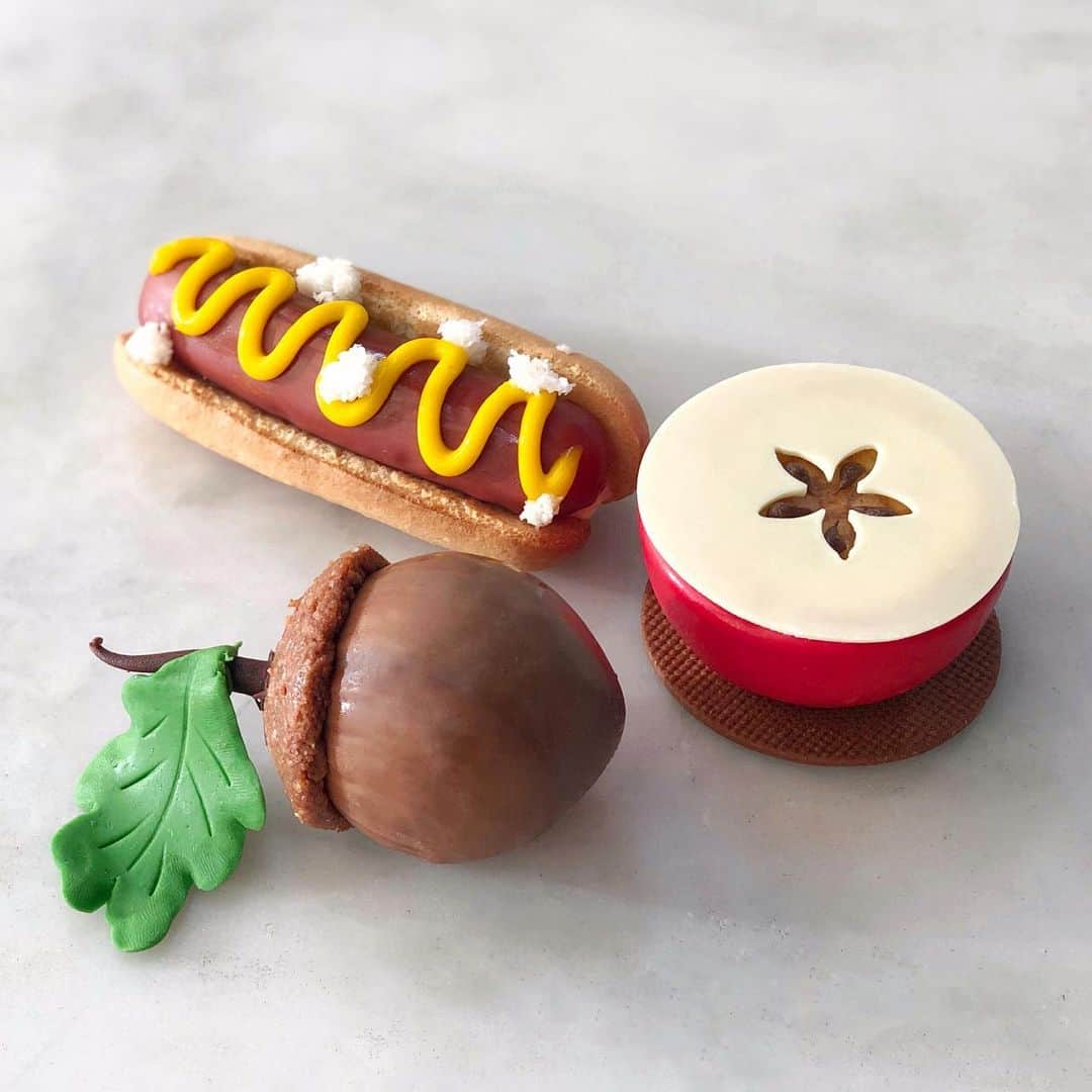 DOMINIQUE ANSEL BAKERYさんのインスタグラム写真 - (DOMINIQUE ANSEL BAKERYInstagram)「Getting ready for our New York Collection, launching in Soho in July 4th through Labor Day, when we turn our pastry case into a tribute to NYC. Here’s a little preview - of our Haute Dog (with raspberry cream, ladyfinger “buns,” and passion fruit “mustard”), A Bite of the Big Apple (with apple compote, fresh Gala apples, vanilla ganache, and vanilla sablé), and A Stroll in Central Park chocolate hazelnut acorn (with blackberry jam and crispy hazelnut feuilletine). ** To celebrate, I’ll be hosting a picnic potluck at a secret location in Manhattan on Friday, July 12th from 3-4:30pm. Tickets are limited and will launch on Eventbrite TOMORROW (Monday 7/1) at 12pm. Link in bio⬆️. Be the first few to snag a (free!) ticket, and you’ll be told the secret location. Bring your best friend, your favorite NYC food to share with the group, and we’ll take care of the drinks and all the dessert! #NewYorkCollection 🍎🥨🥯🌭🗽」7月1日 2時43分 - dominiqueansel