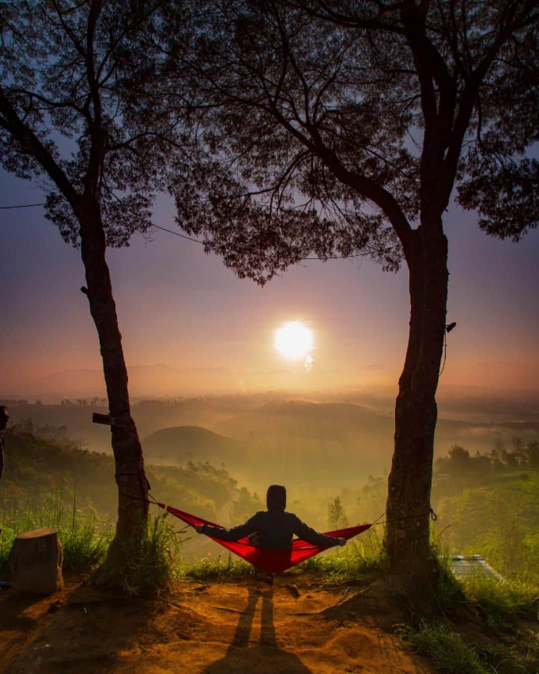 Canon Asiaのインスタグラム：「“Sunrise hunting is my hobby. Located 1-2 hours away from the heart of Bandung city, the Cukul Sunrise Point that I visited provides a stunning view of the mesmerizing sunrise. This point rests on a cliff, overlooking the Malabar tea garden and the majestic Malabar mountains.” • Besides using a long exposure setting to capture the fleeting colours of dawn 🌄 at its most vivid, explore the use of complementary colours! Here, the red 🔴 of the hammock accents the verdant greenery 🌲 of the mountains, adding further interest to the harmony of colours. • 📷 Image by @dedot09 shot using the Canon EOS 6D | Canon EF 17-40mm f/4L USM | f/9 | 1/50s | ISO 50 | 40mm  Want your photos to be featured too? Tag them with #canonasia !  #canonasia #photography #sunrise #landscapephotography #bandung #indonesia_photography #indonesia」