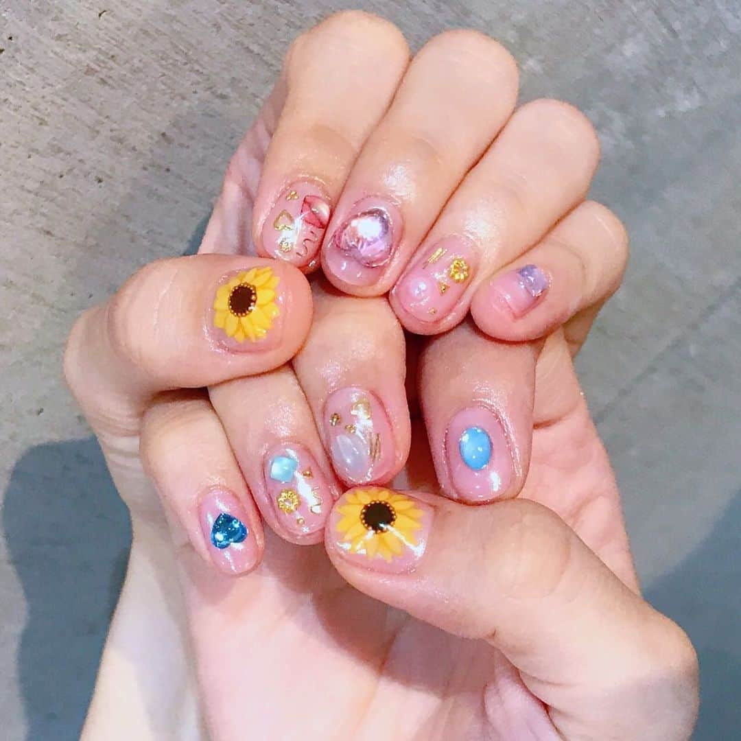 ぱいぱいでか美のインスタグラム：「久しぶりにLovlでネイル❤︎ 新しい店舗も落ち着ける空間でした。 ꙳ #lovl #lovlnail #nailsalon #表参道 #ひまわりネイル ꙳ 昨日も投稿したんだけど不具合エグくて一旦削除しちゃったので再投稿……！ 昨日コメントやいいねくれた人すみません良かったらもう一回ください(T . T) というわけで改めましてlovl行ってきました❤︎ 夏らしく親指にひまわり☻ 雨多くても爪を見れば夏の気持ちになれるね。 左はピンク、右はライトブルーのパーツでキラキラに！ ベースもオーロラなので華やかだけど品があってかわいいね〜 Lovl渋谷にもありますが先日表参道にも出来て 初めて行ってきました！ 落ち着ける空間でネイルしてもらいながら寝るかと思いました。笑」