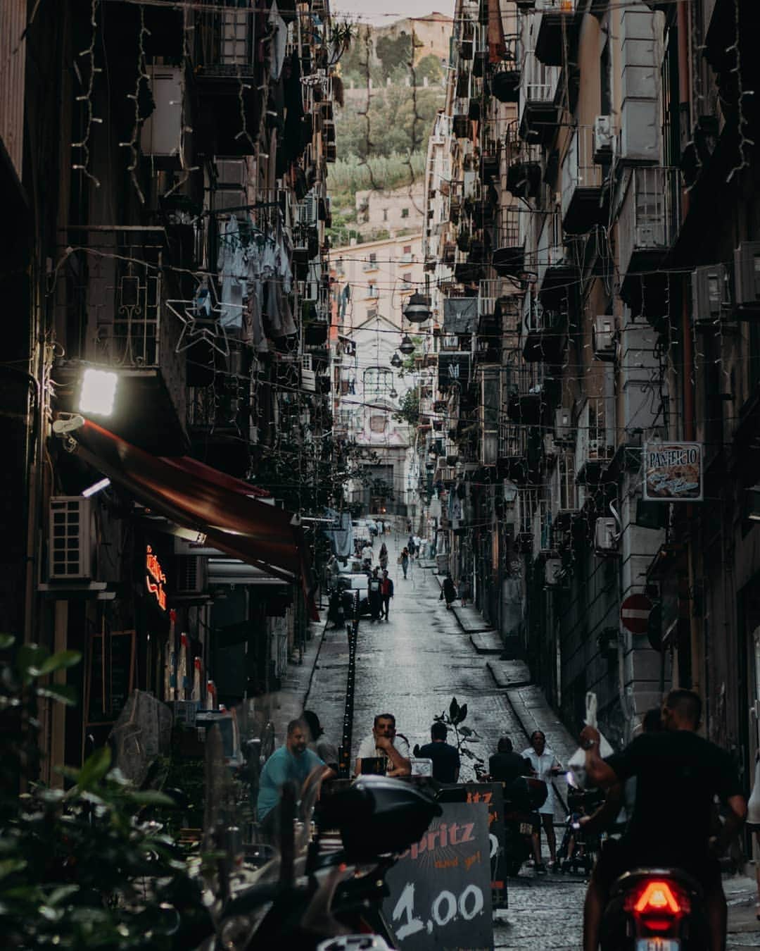 Putri Anindyaのインスタグラム：「Half day in Napoli // I stayed in Pompeii for two nights and decided to visit Naples for the sake of my fav pizza, Neapolitan. Because @capra311 knew how small and chaotic the streets in Naples, he decided to park the car and bought the metro ticket to shoot around. The problem was, the metro line 1 is not working that day. So we took the other line and Voila, we arrived to this market with chaos everywhere. . .  A very surprising welcome for me and felt a little bizzare cause somehow it looked a little like Bekasi or Jakarta market area. The smell of the trash, fish, motorcycle pollution, food, like mixed into one. Everywhere you look there will be motorcycle. It feels like home a little until someone looked at me and called me "turismo" when i took pict of Maradona grafitti. I almost answered to him, "no shit i am" but i don't want to make a trouble in this city lol. Anyway i loved the picts that i took here so i will share more of Napoli picts soon!」