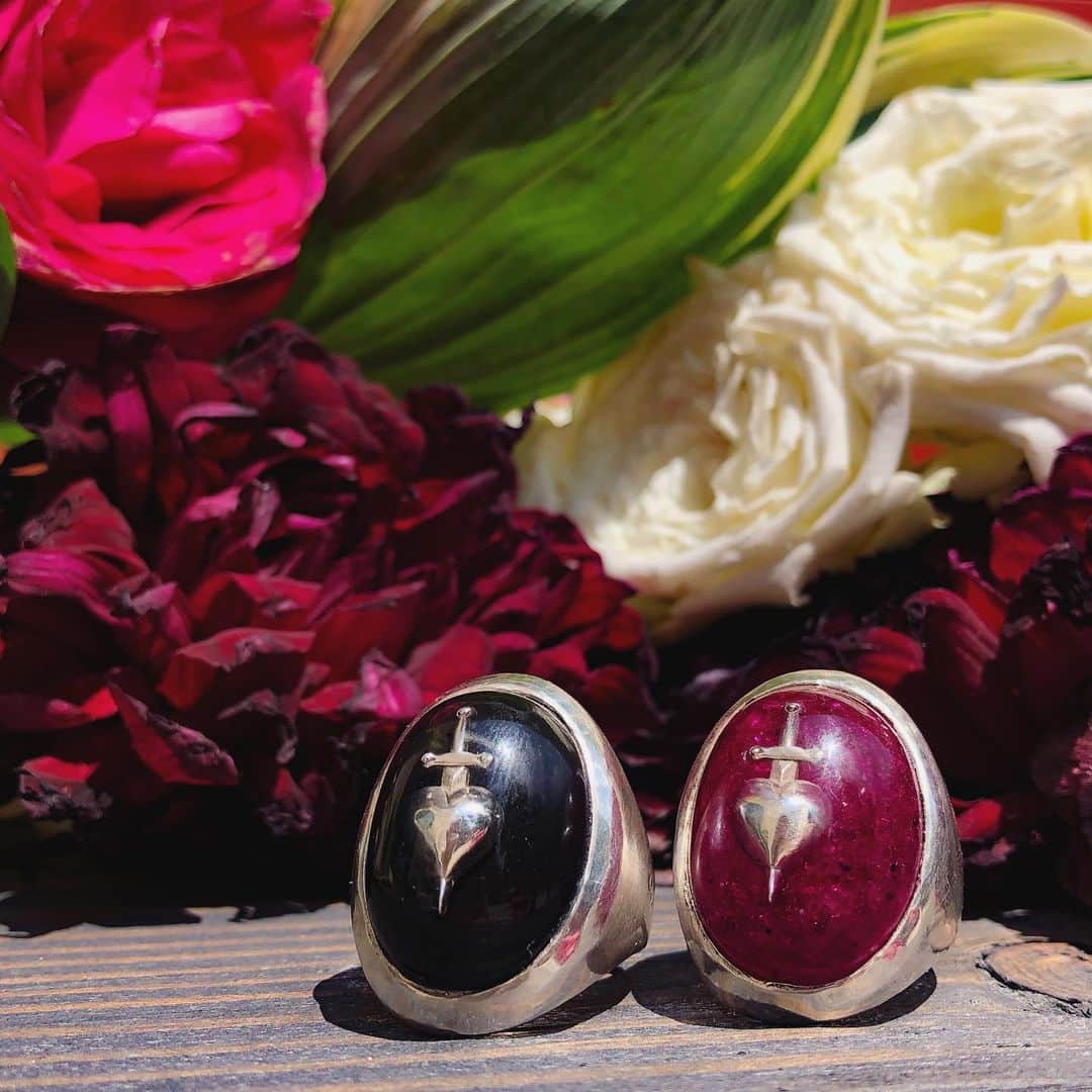 のインスタグラム：「The Sword-Pierced Heart ring is a brand-new addition to the world of Medieval-inspired works by Alex Streeter. This bold yet sophisticated ring is available in Black and Crushed Ruby - perfect for both men and women looking to add a unique statement piece to their collection. Ruby has long been considered a talisman of love and was a once a very popular choice for engagement rings. This motif was originally inspired by medieval portraits of the Virgin Mary, who is often depicted with a sword through her heart. Our version symbolizes the eternal struggle between passion and heartache; love and loss. 🗡Available in the Medieval Section at AlexStreeter.com or visit the link in Bio」