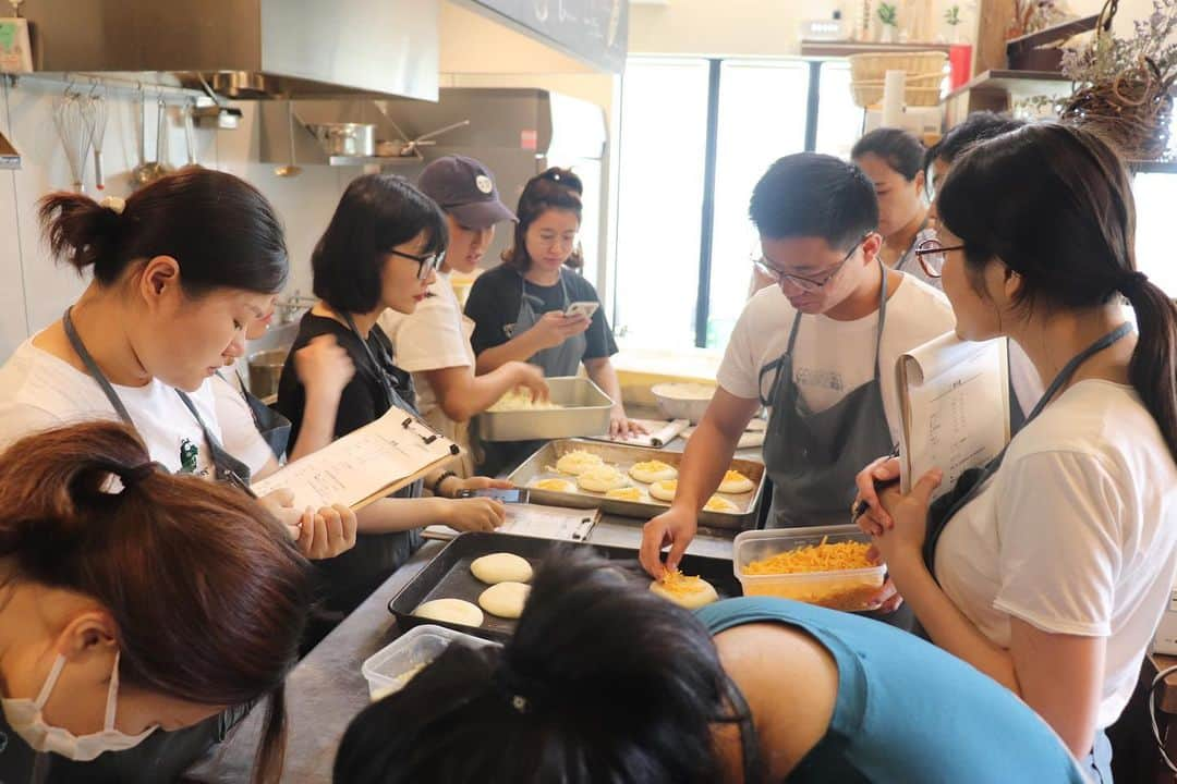 丘の上のパン屋 さんのインスタグラム写真 - (丘の上のパン屋 Instagram)「丘の上のパン教室〜中国編〜﻿﻿ ﻿﻿ 本日と明日はお店の定休日で、中国の方へのパン教室を開催中です。﻿﻿ ﻿﻿﻿ 中国でパンはまだ発展途上にあり、なかなかレパトリーも少ないとのことで、同じ生地でいろんなパンを作る方法や、個人店でいかに効率良く販売していくか、などなど様々なことをお伝えさせて頂いています。﻿﻿ ﻿﻿ 人に伝えることで、今まで無意識にやっていたことも改めて考えたり、頭の中を整理したりとこちらも勉強させてもらい、刺激になり、とても良い機会を頂いたと思っております。﻿﻿ ﻿﻿ 今日はフォカッチャやエッグタルト、デニッシュの成形などをしています。﻿﻿ ﻿﻿ せっかく日本まで来て下さっているのだから、為になることを伝えられるよう頑張ります！﻿﻿ ﻿﻿ ※今週10日(水)は振替休日のためお休みとなります。﻿﻿ ﻿﻿﻿ ------------﻿﻿﻿ ﻿﻿﻿ 7月、8月の臨時休業、夏季休業のお知らせ﻿﻿ ﻿﻿﻿ ●7月8日、9日は「丘の上のパン教室(中国の方向け)」のためお休み、10日は振替休日となります。﻿﻿﻿ ﻿﻿﻿ ●7月29日〜8月9日から台湾講習のためお休みです。﻿﻿﻿ ﻿﻿﻿ 変則になりますので、サイトのカレンダーをご確認ください。﻿﻿﻿ ﻿﻿﻿ −−−−−−−−−﻿﻿﻿﻿ ﻿﻿﻿﻿ 💬 マイバックをご持参ください﻿﻿﻿﻿ ﻿﻿﻿﻿ 19年8月から、レジ袋が1枚5円となります。﻿﻿﻿﻿ ぜひマイバックのご持参お待ちしております。﻿﻿﻿﻿ ゴミ削減にご協力お願い致します。﻿﻿﻿﻿ ﻿﻿﻿﻿ ﻿﻿﻿ −−−−−−−−−﻿﻿﻿﻿ ﻿﻿﻿﻿ 💬 スタッフ募集中です﻿﻿﻿﻿ ﻿﻿﻿﻿ 新たに一緒に働いてくれる仲間を募集しております。﻿﻿﻿﻿ ﻿﻿﻿﻿ 応募方法は郵送となります。﻿﻿﻿﻿ 詳細はサイトをご確認ください。﻿﻿﻿﻿ ﻿﻿﻿﻿ −−−−−−−−−﻿﻿﻿﻿ ﻿﻿﻿﻿ 💬 ご予約について﻿﻿﻿﻿ ﻿﻿﻿﻿ ●予約可能商品﻿﻿﻿﻿ ・食パン ﻿﻿﻿﻿ ・カンパーニュ﻿﻿﻿﻿ ・バゲット﻿﻿﻿﻿ ・エッグタルト﻿﻿﻿﻿ ﻿﻿﻿﻿ ※グルテンフリー米粉パン(プレーン、大納言)﻿﻿﻿﻿ ※低糖質ふすまパン(3本から)﻿﻿﻿﻿ ※一升パン﻿﻿﻿﻿ (※は木、金のお渡しになります)﻿﻿﻿﻿ ﻿﻿﻿﻿ 📞 045-530-9683（クロワッサン🥐）﻿﻿﻿﻿ ﻿﻿﻿﻿ −−−−−−−−−﻿﻿﻿﻿ ﻿﻿﻿﻿ 🛒 オンラインショップ﻿﻿﻿﻿ ﻿﻿﻿﻿ グルテンフリーの米粉食パンの﻿﻿﻿﻿ 通販を行っております。﻿﻿﻿﻿ サイトからご確認ください。﻿﻿﻿﻿ ﻿﻿﻿﻿ ﻿﻿﻿ −−−−−−−−−﻿﻿﻿﻿ 🏷﻿﻿﻿﻿ #丘の上のパン屋  #横浜 #青葉区 #たまプラーザ #ベーカリーカフェ #パン屋 #パン #パン屋さん #横浜パン屋 #🍞 #焼き立てパン #美しが丘 #美しが丘西 #田園都市線 #天然酵母 #国産小麦 #bakery #boulangerie #boulanger #yokohama#instabread #instafood #pane #sourdough #naturalyeast﻿﻿﻿﻿ ﻿」7月8日 16時36分 - okanouenopanya