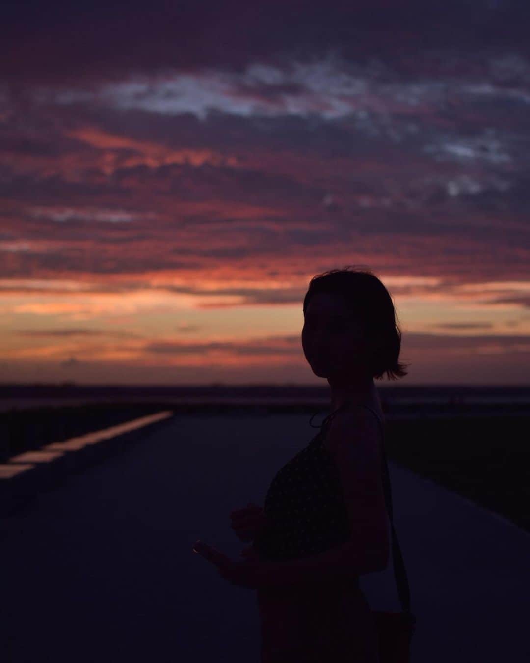 永井志帆のインスタグラム：「めっちゃ綺麗な夕焼けをみたー 瀬長島のテラスおススメです。また行きたいな。  ここで氾濫バーガーなるでっかいハンバーガーとサーターアンダギーとブルーシールアイスのコラボという禁断のおやつを食べた🍪最高ですなぁ。  #瀬長島#瀬長島ウミカジテラス #夕焼け#沖縄#夕方#氾濫バーガー#サーターアンダギー#ブルーシールアイス#沖縄グルメ#kameandagi#沖縄観光」