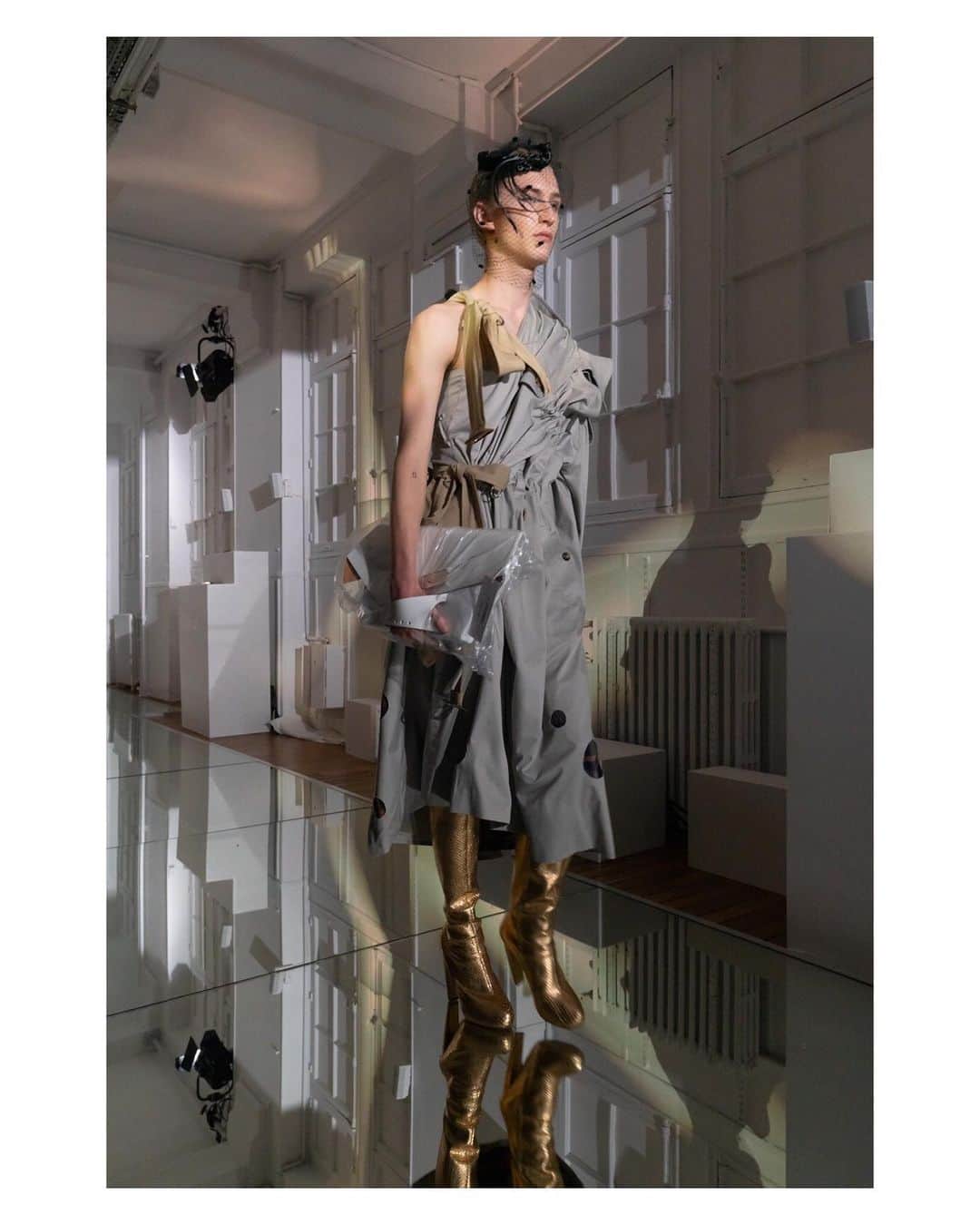 Maison Margielaさんのインスタグラム写真 - (Maison MargielaInstagram)「Putty-coloured trench coat cut into an asymmetrical dress finished with a nude trench belt and hand-cut holes. Gold snakeskin boots, white leather Snatched handbag and a black plumed veil hat. Look 26 from Artisanal Co-ed Collection AW19 designed by @JGalliano #MaisonMargiela」7月10日 14時54分 - maisonmargiela