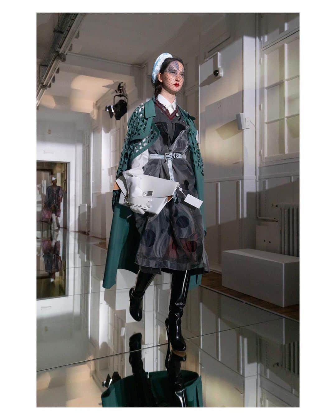 Maison Margielaさんのインスタグラム写真 - (Maison MargielaInstagram)「Seafoam-coloured trench coat with hand-cut holes worn over a printed wool and white crin dress with hand-cut holes, a grey polyamide sleeveless knit, and a white shirt. Black box leather boots, white calfskin Snatched handbag and a white-painted blue veiled beret. Look 29 from Artisanal Co-ed Collection AW19 designed by @JGalliano #MaisonMargiela」7月11日 14時53分 - maisonmargiela