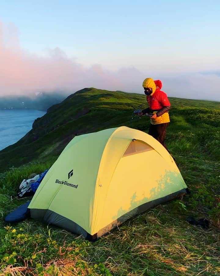 クリス・バーカードのインスタグラム：「Kuril Islands day 4: Sunrise shines on the small ridge where we made camp on the edge of the Onekatan volcano. Nowhere on this island is protected from the wind. In fact the cold volcanic lake that acts as a mote around the volcanic cone creates an inversion and sucks the clouds over the rim. Lenticular clouds formed all day as we watched clouds move like a swift river over the landscape. We pushed through the hike with 50-80lb packs of camera gear & shot our way through the sunset & crescent moon into night. Sleeping didn’t seem like an option when our Russian team said this was the best conditions that they have ever seen here. .  @renan_ozturk  @tedhesser @_ryanhill_ @taylorfreesolo #fromkurilswithlove」
