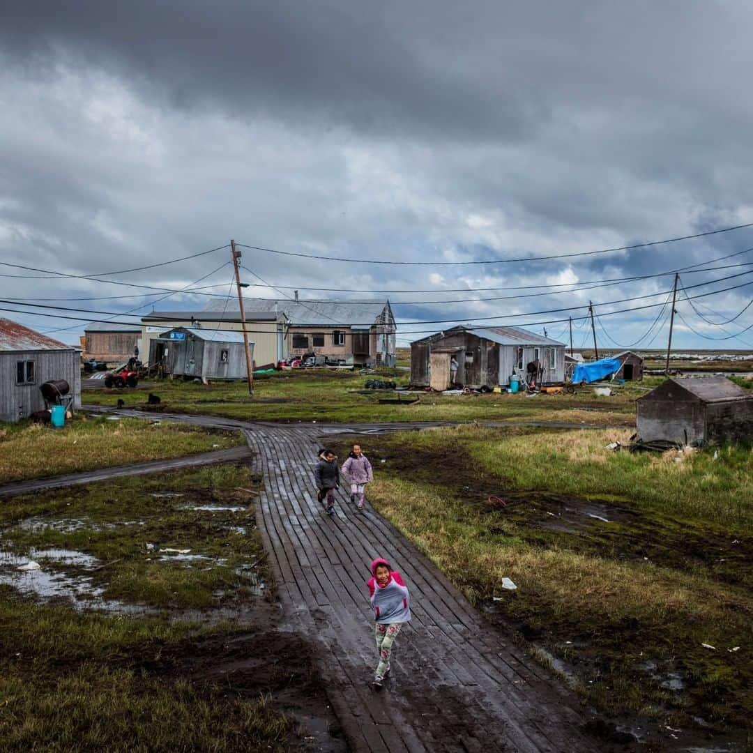 ナショナルジオグラフィックさんのインスタグラム写真 - (ナショナルジオグラフィックInstagram)「Photo by Katie Orlinsky @katieorlinsky | Wooden walkways replace roads, and homes rest on pilings in the village of Newtok in western Alaska. This Yupik village (population 380), located along the Ninglik River in the lower Kuskokwim Delta, is sinking as the permafrost beneath it thaws. The entire village is in the process of moving to Mertarvik, a new village site about nine miles away built on rocky ground.」7月12日 15時39分 - natgeo