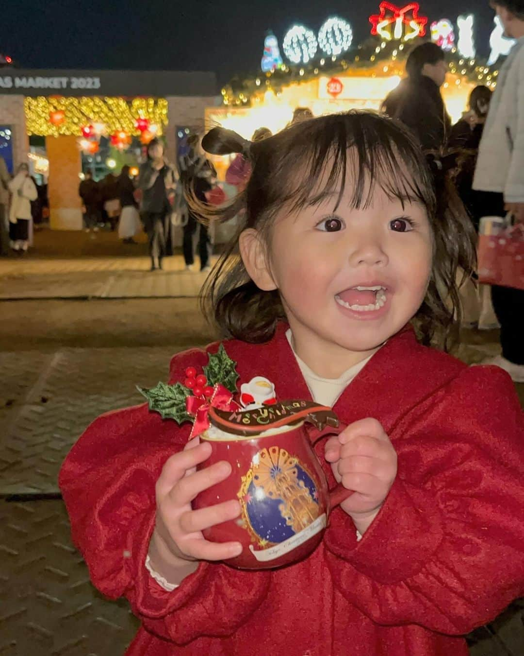 はやめいのインスタグラム：「. 東京クリスマスマーケット 🎅🏼🎄.*🦌   事前に調べた時に娘が飲みたい！と 言っていたココアを買えて嬉しそうな お顔です 👧🏻 ◎  彼から「めいちゃんと👧🏻ちゃんと ここに行きたいんだ〜☺️」と 提案してもらっていてやっと行けました 🫶🏻  娘も目を輝かせていました （ ᵔᵔ ）  日付の感覚がまだ無いので 「今日もサンタさんきてないんだけど 〜 🙂」と いつサンタさんはくるのかわかって いないところもまたかわいいです 笑 🤭  #クリスマスマーケット#tcm2023 #東京クリスマスマーケット #クリスマスコーデ#クリスマスデート #外苑前#明治神宮外苑」