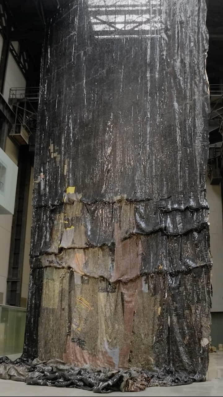 テート・ギャラリーのインスタグラム：「‘I use multiple elements to talk about the world: not a world made up of just one culture, but a world shaped by all of us coming together.’ – @ElAnatsui_Art ⛵ 🌙  ✨  In this film, we travelled to Ghana to meet El Anatsui and see the construction of his monumental installation for Tate Modern’s Turbine Hall. Made of thousands of metal bottle tops and fragments, ‘Behind the Red Moon’ engages with the poetic possibilities of materials and the migration of goods and people during the transatlantic slave trade. Sourced in Nigeria, the materials used in this commission form part of a present-day industry built on colonial trade routes.  🌒 🌍  El Anatsui’s Hyundai Commission: #BehindTheRedMoon is on free display at Tate Modern until 14 April 2024. In partnership with Hyundai Motor.」