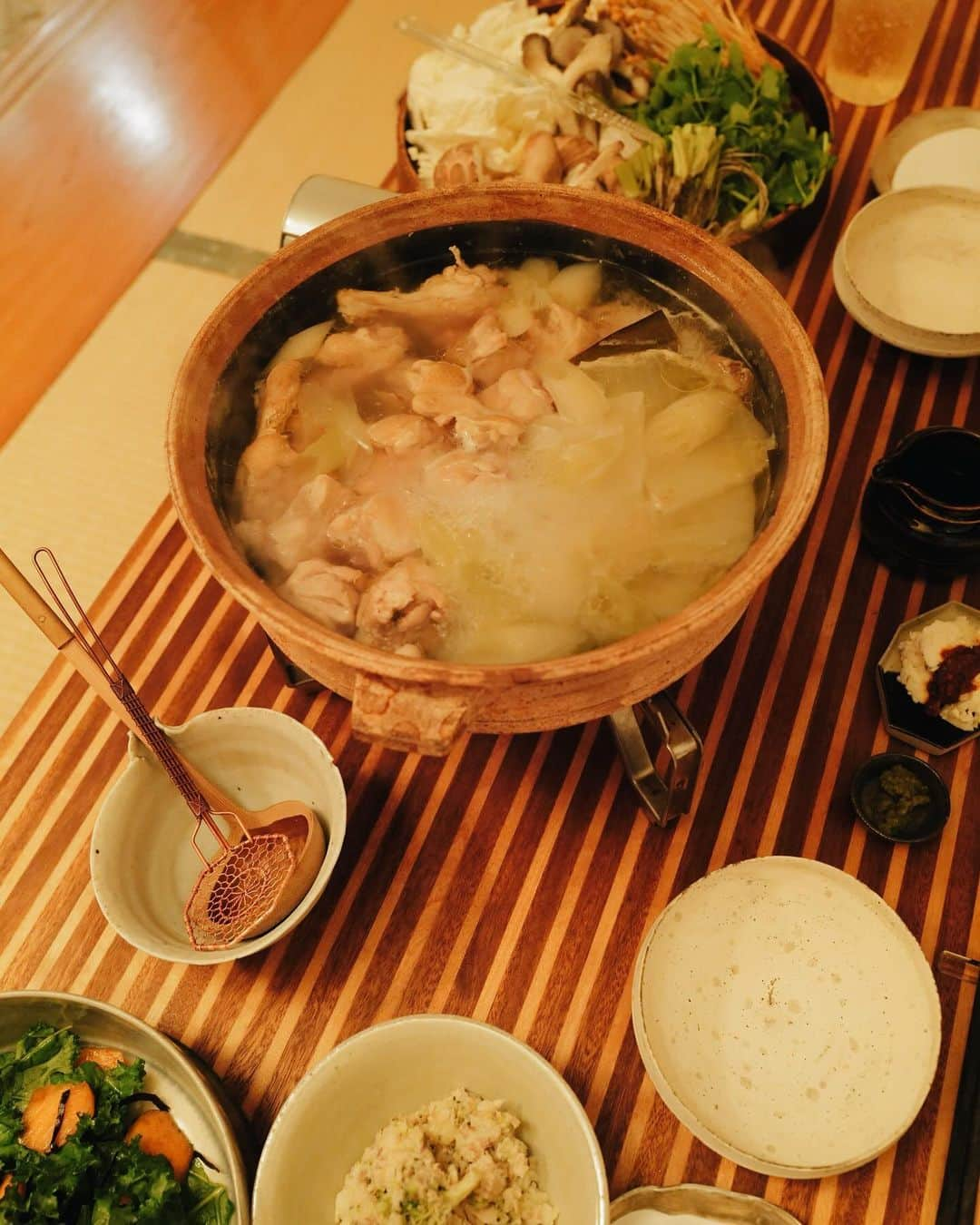 高山都さんのインスタグラム写真 - (高山都Instagram)「昨日は水炊き🍲 土鍋に昆布と水と生姜とネギの青い部分を入れて沸いたら、ハサミを入れた鶏手羽元を入れ、アクをとりながら3〜40分コトコト弱火で煮て、塩麹を揉み込んだ鶏もも肉も入れて、ネギや白菜を入れて、塩で味を整える。 それだけです。 本当に美味しい。 天然の旨みだけで、スープを存分に味わえる。 鶏肉はほろほろで、箸で引き上げられないほどの柔らかさになります。 野菜は、白菜、いろんなキノコ、セリにしました。 柚子胡椒やポン酢は各々で好きなように。 わたしはほんの少しだけ垂らすくらいが好み。 お鍋だと、翌日の身体が軽い。 量が多いかなと思いつつ、お野菜たくさん食べれてしまう不思議。」12月15日 8時32分 - miyare38