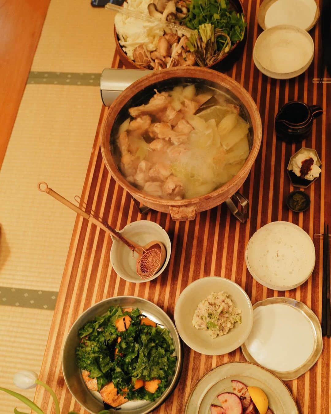 高山都のインスタグラム：「昨日は水炊き🍲 土鍋に昆布と水と生姜とネギの青い部分を入れて沸いたら、ハサミを入れた鶏手羽元を入れ、アクをとりながら3〜40分コトコト弱火で煮て、塩麹を揉み込んだ鶏もも肉も入れて、ネギや白菜を入れて、塩で味を整える。 それだけです。 本当に美味しい。 天然の旨みだけで、スープを存分に味わえる。 鶏肉はほろほろで、箸で引き上げられないほどの柔らかさになります。 野菜は、白菜、いろんなキノコ、セリにしました。 柚子胡椒やポン酢は各々で好きなように。 わたしはほんの少しだけ垂らすくらいが好み。 お鍋だと、翌日の身体が軽い。 量が多いかなと思いつつ、お野菜たくさん食べれてしまう不思議。」