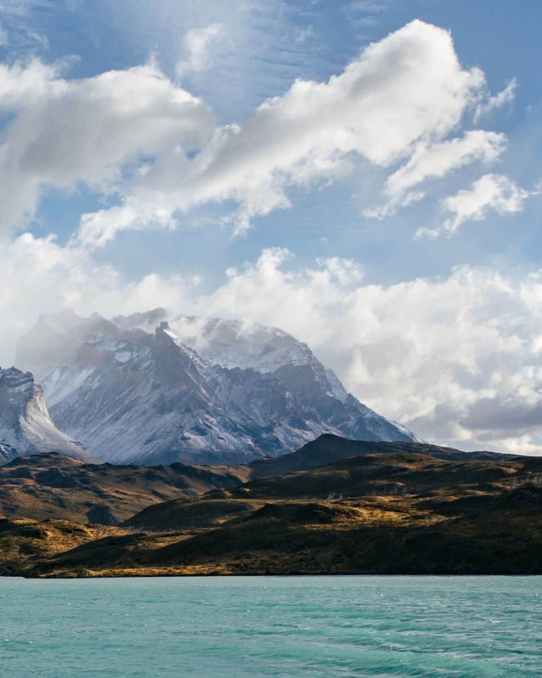 National Geographic Travelさんのインスタグラム写真 - (National Geographic TravelInstagram)「Photos by @michaelgeorge | Chilean Patagonia’s Torres del Paine is the rare park where humans are true outsiders in a vast, legitimate wilderness. Though it occupies 930 square miles (2,400 sq km), the park received only 140,000 visitors throughout 2022. Compare that with Zion National Park, where last year close to 4.7 million people explored its 232-square-mile (600-sq-km) expanse.  This image was captured as I traveled over Lago Pehoé, which translates to “hidden lake.” The brilliant color is caused by glacial flour, or rock dust suspended in the water. Prior to visiting Torres del Paine, I presumed all photos I’d seen of it had the saturation turned up to exaggerate the colors. I was pleasantly surprised that this is not so—those colors are precisely how they look. It’s as if all the natural features that make a landscape beautiful are turned up a notch. In the distance you can see Macizo Paine, a group of mountains that look like broken teeth.」12月15日 14時44分 - natgeotravel