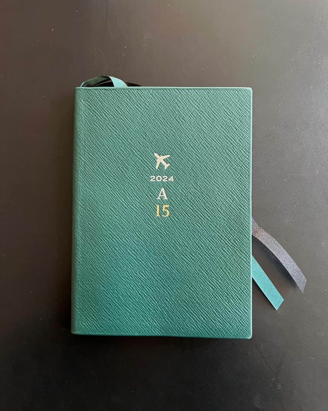 あだちなみのインスタグラム：「15冊目📖 @smythson  2024年のスケジュール帳 箔押しが出来上がってきました、素敵  新しい場所へ飛び立ちたい、という思いを乗せて飛行機を選びました あとはいつも通り、あだちのAと15冊目の15  （2024は始めから入っています）  私の好きな深緑色 小口はシルバー グログランリボンの栞2本 箱に入っているロイヤルワラントは3つから2つに  来年1年毎日一緒に過ごす大切な友📖 15冊目＝15年目、年数にするとドッキリしちゃう笑  #smythson #royalwarrant #vulcanizelondon  紅林さん今年もありがとうございました😊」