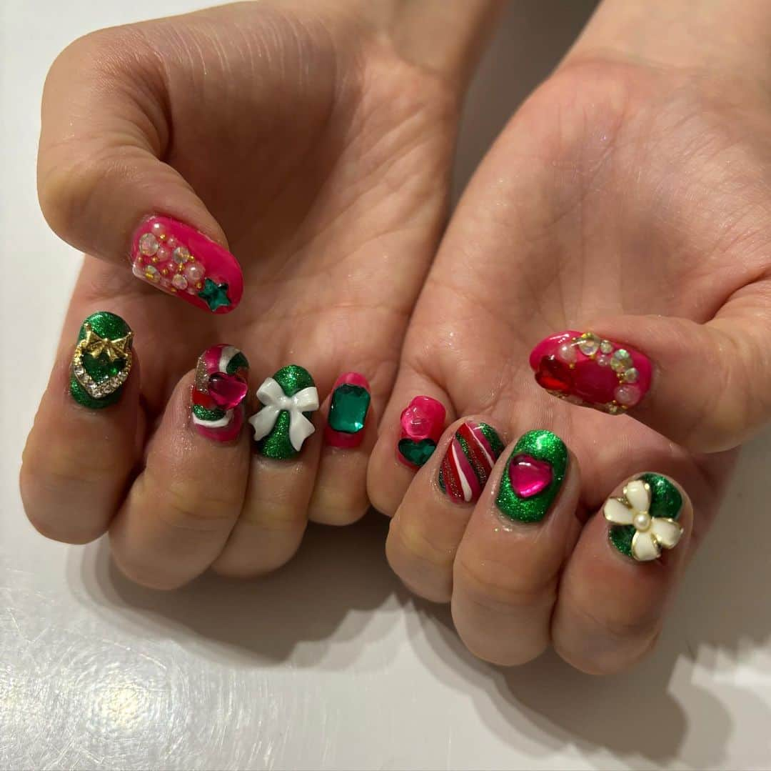 ケリーアンのインスタグラム：「#クリスマスネイル 💗🎄  友達のまおちゃんは💗×💚配色が大好き！ パーツ盛り盛り、ストーンでツリーとリースも作ったよ✨  @nanakara_jp カラージェル 040M, 043M, 001MW ノンワイプトップジェル  ・マグネットパウダーとパーツは持ち込み ・左手は数本自爪が折れてるから短めにカット  #ジェルネイル #セルフネイル #セルフジェルネイル #ネイルアート #gelnails #nails #nailart #マグネットネイル #ラメネイル #ビジューネイル」