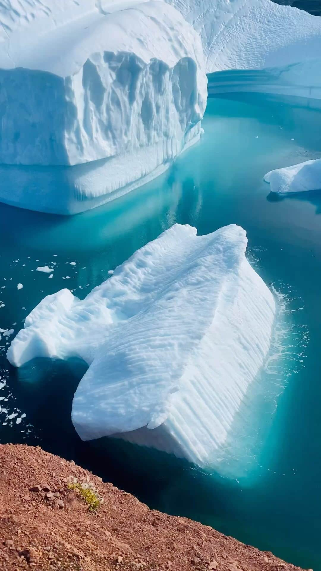 Discover Earthのインスタグラム：「Captured in the raw, untamed beauty of Greenland, this towering iceberg succumbs to nature’s relentless force, dramatically breaking and turning. A powerful reminder of our planet’s fragile majesty.  📍Greenland  🇬🇱 #DiscoverGreenland with @thelaidbackcompany @chrishenry and @nordicalex」