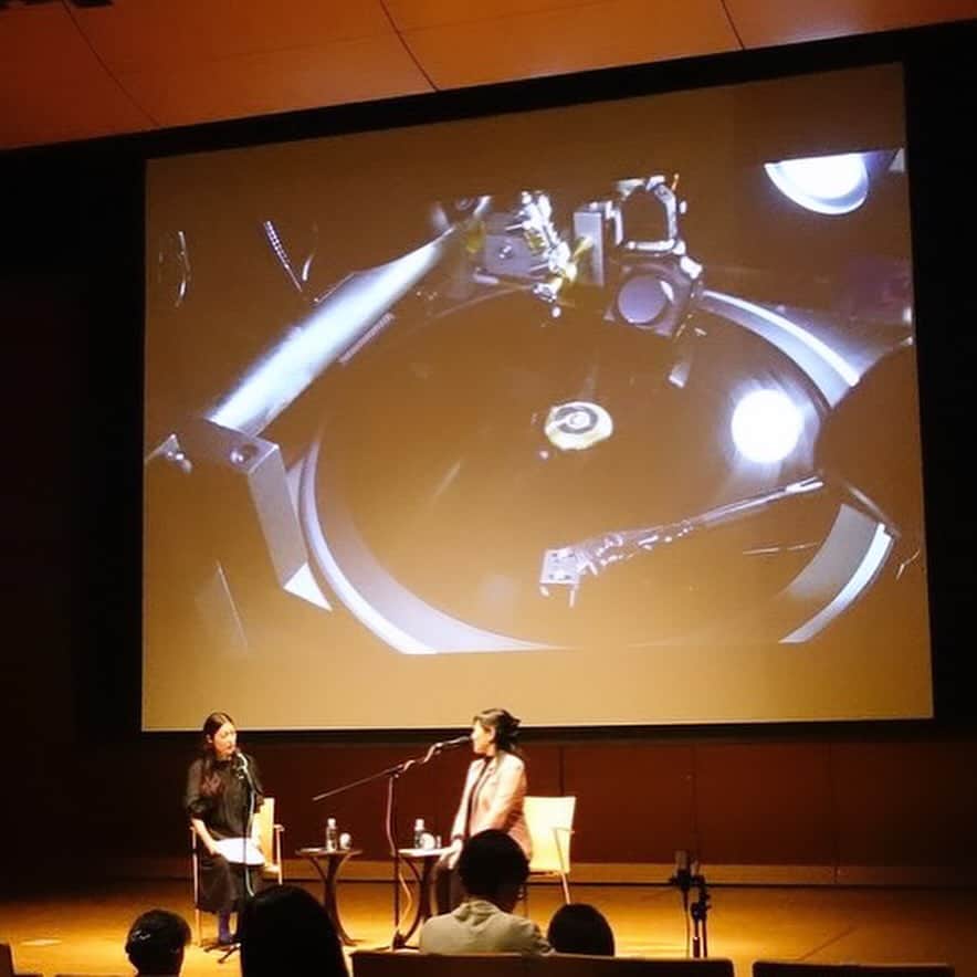 小林エリカのインスタグラム：「【柳井イニシアティブ】レコードプロジェクト『におう when we were together inhaling the same scent』にお集まりくださったみなさま、プロジェクトのみなさま、ありがとうございました。  こちらはレコードカッティングの様子！  「ごぞんじですか？核爆発のあとでオゾンのとてもいいにおいがするんですよ。」「水爆の父」とよばれたアンドレイ・サハロフ博士の言葉の引用の朗読にはじまり、ギリシア語、ὄζειν (Ozein)（オーゼィーン）「におう」に由来するオゾンのことなどについて対話しました。 空気の振動によりダイレクトにレコードの溝が刻まれてゆくのを見るなか(A面B面　きっちり20分ずつ！）みなさまと一緒に目に見えないにおいを考え、その場で麻希さんによる「オゾンのにおい」を一緒にかぎ、言葉にするという貴重な体験になりました。最後みなさまが書いてくださったにおいの言葉壮観でした！ 出演：上田麻希 @makiueda 、小林エリカ　 レコードカッティング： 山根アツシ @altphonic  ポスターデザイン: 田部井美奈 柳井イニシアティブ  [The Yanai Initiative] Record Project "Nio-u: when we were together, inhaling the same scent."  Thank you to everyone who gathered for this event.   “Did you know? After a nuclear explosion, there's a very distinct and pleasant scent of ozone. “ The session began with the reading of a quote from Dr. Andrei Sakharov, known as the 'father of the hydrogen bomb': We discussed invisible things, ozone, derived from the Greek word ὄζειν (Ozein), meaning 'to smell.'   As the record grooves were cut(20min each, side A and B）directly by the aerial vibration, we shared a invisible unique experience inhaling “scents of ozone” created by Maki together, and putting it into words. The compilation of scents described by everyone at the end was spectacular!   Maki Ueda  Erika Kobayashi  Record Cutting:Atsushi Yamane  Poster Design:Mina Tabei  The Yanai Initiative  Photo by @altphonic」