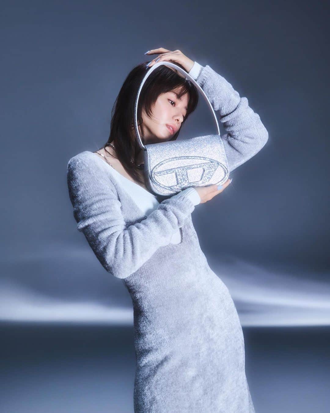 The Fashion Postさんのインスタグラム写真 - (The Fashion PostInstagram)「#fashion DIESEL with Maika Yamamoto 『1年を締めくくる特別な冬に。山本舞香が出会う、ディーゼルと迎えるホリデー 〈前編〉』  ブランドのアイコンバッグである「1DR」のショルダーバッグを小粒のラメをふんだんに使用した生地に一新。バッグ本体よりも光を放つように、オーバル D ロゴのメタルプレート部分はあえて大粒のラメを採用しているので、動かすたびに光を反射し、華やかな仕上がりに。取り外し&長さ調節可能なレザーのストラップつきで 2WAY 仕様。  バッグのシルバーから紐解き、合わせるスタイリングはメタルのオーバルDプラークがほどこされたグレーのミニドレスをチョイス。ネックレスやピアスでシルバーを散りばめることで、ホリデーらしい輝きが増すとともに、さらにまとまりよく。高品質のビスコースシェニール糸をブレンドしたタイトな形のドレスは、品のあるツヤとなめらかなタッチも魅力。  model: Maika Yamamoto photography: Toki videography: Kohei Igarashi styling: Yuka Sakakibara hair & make up: Rei Fukuoka edit: Yuko Igarashi & Natsume Horikoshi text: Yuko Igarashi  #tfp #thefashionpost #DIESEL #ディーゼル #山本舞香 #MaikaYamamoto #pr」11月24日 23時00分 - tfpjp