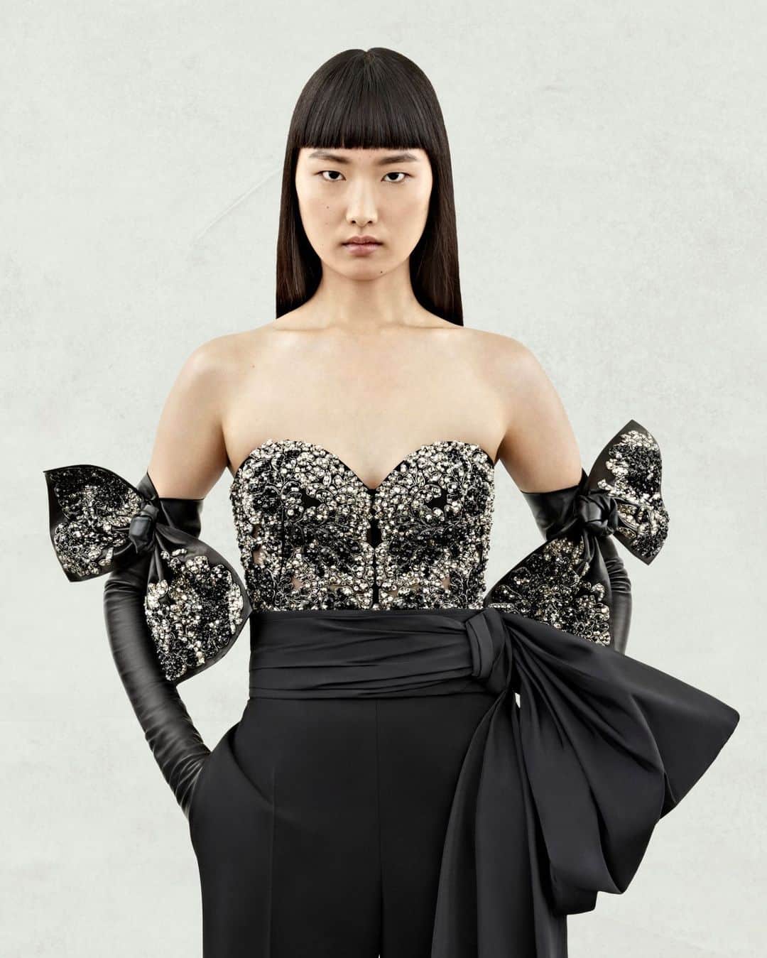 アレキサンダー・マックイーンのインスタグラム：「A #McQueenPreSS24 black tulle corset with crystal chiaroscuro flower embroidery, tailored high-waisted trousers and gloves with bow detailing. ⁣ ⁣ Discover the collection via the link in bio.⁣ ⁣ Photographed by @Jet.Swan」