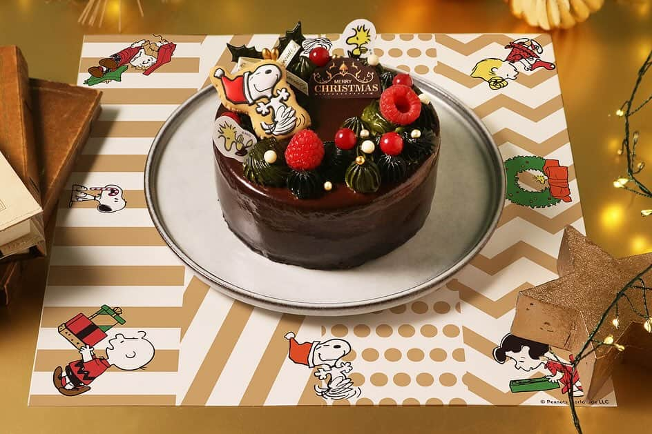 ピーナッツ カフェさんのインスタグラム写真 - (ピーナッツ カフェInstagram)「new | PEANUTS Cafe オンラインショップ  \ HAPPY HOLIDAYS！ / PEANUTSファン必⾒！毎年恒例PEANUTS Cafeのクリスマスケーキ！  今年は、チョコレートケーキをベースに、リースをイメージしたシックで大人なデザインに仕上げました。    □CHRISTMAS ケーキ 2023　 ￥6,156(tax in)   ふんわりとした食感のショコラジェノワーズ、ミルクチョコレートとフランボワーズを合わせたクリームに赤い果実でほんのり甘酸っぱさをプラスしました。   シンプルながら、チョコレートの風味をしっかりと感じていただける仕上がりです。  ウッドストックのピックやチョコレートプレートがトッピング。  クリスマスを楽しむスヌーピーのアイシングクッキーやオーナメントはご自身でお好きな場所にデコレーションしてお楽しみいただけます。   ————————  ＜セット内容＞  アイシングクッキー 1個  クリスマスオーナメント(ヒイラギ １本/ウッドストックピック ２個) 缶バッジスタンド 1個  クリスマスペーパーランチョンマット 1枚  食べ方リーフレット　１枚  ロウソク 5本   ＜サイズ＞  12cm (2～4人分)   ＜予約開始日＞  11月21日(火)午前10:00〜  ※なくなり次第終了いたします。   ＜お届け期間＞  12月1日(金)〜12月25日(月)  ※お届け集中緩和のお願い※  お届け日が、12/23.24は集中するため、事前の受け取りをお願い致します。   ＜美味しくお召し上がりいただくために＞  お皿に移してから冷蔵庫に6〜12時間入れてゆっくり解凍してください。  ※解凍後、48時間以内にお召し上がりください。  ※商品は冷凍便(クール便)でのお届けです。   ————————  家族や大切な人との特別な日は、スヌーピーとウッドストックのクリスマスケーキで素敵なひと時をお過ごしください。   -販売店舗  PEANUTS Cafe オンラインショップ  ※商品は冷凍便(クール便)でのお届けです。  ※なくなり次第終了いたします。  詳しくは、@peanutscafe_tokyo トップのリンクより、HPにてご確認ください。」11月25日 19時38分 - peanutscafe_tokyo