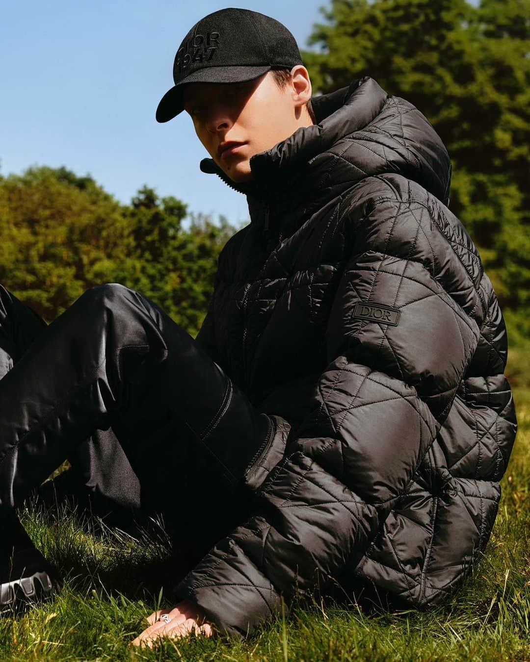 のインスタグラム：「Formal meets informal, prioritizing ease for the wearer, in the #DiorSpring24 men's collection by @MrKimJones. Pictured here, a hooded down jacket sports an all-over tonal quilted Cannage motif and a snug gray wool and cashmere sweater is striped with the season's colorful 'Dior Multi' signature, with a sustainable denim bucket or a refined 'CD Icon' chain link bracelet accessorizing looks.  © @AlasdairMcLellan」