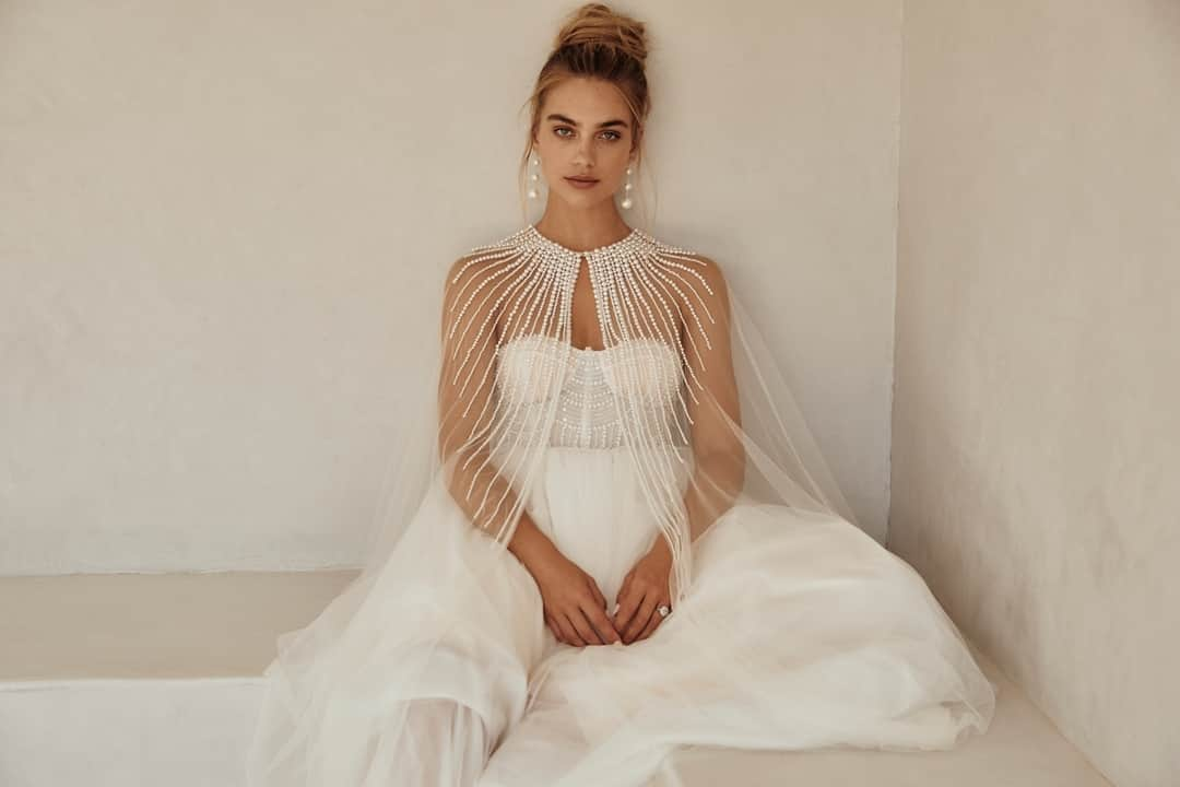 キャサリンディーンのインスタグラム：「If you’re looking for that special piece to elevate your wedding day look and feel like royalty, we have the perfect item for you. 🥰⁣Our delicate Stardust Cape  Rows of elegant pearls adorn the fine tulle Stardust cape. A show-stopping piece to add to your big day!  #catherinedeane #bridalcollection #bridalseparates #separates」