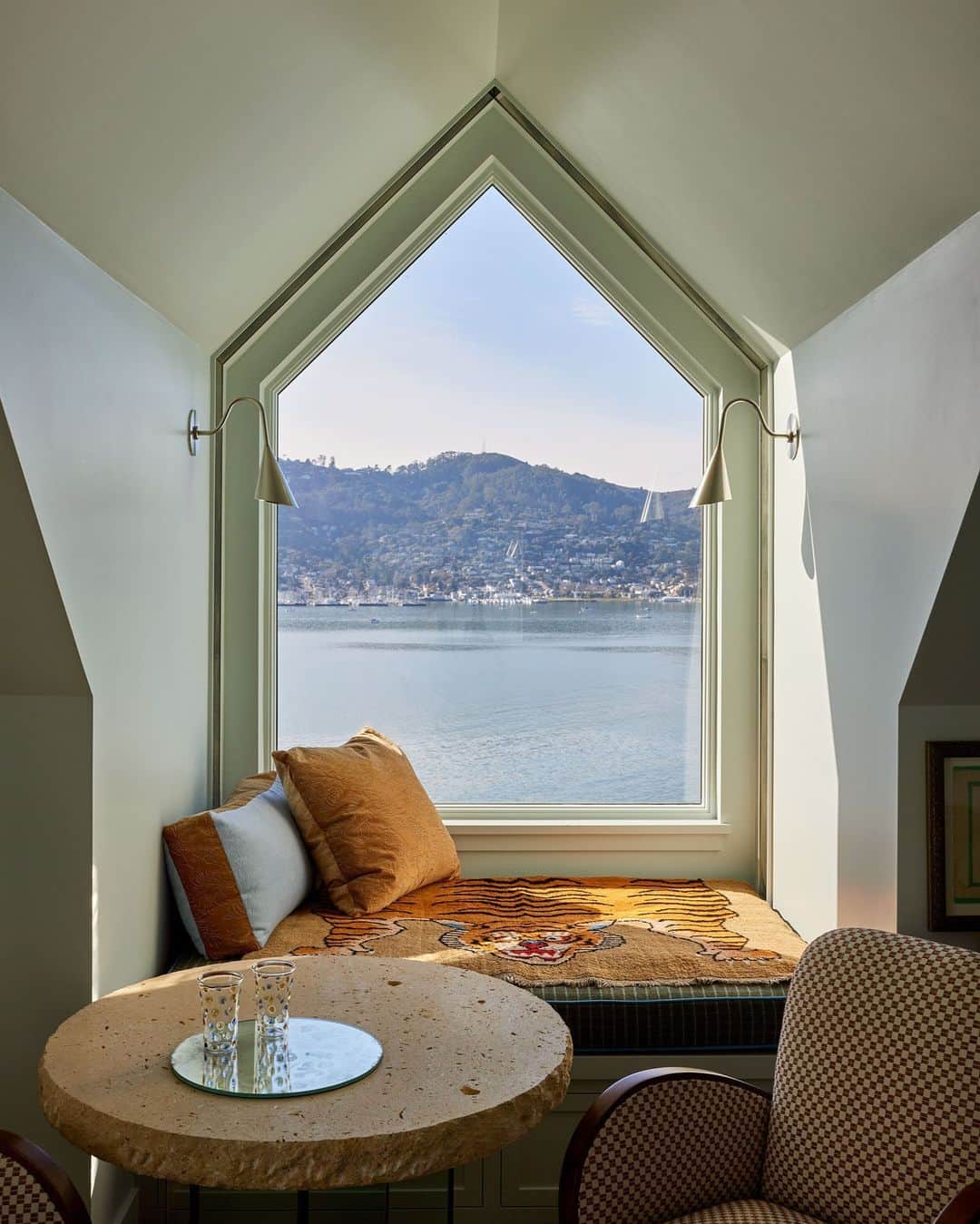 ELLE DECORのインスタグラム：「A San Francisco resident, designer Lauren Geremia (@geremia_design) sees the water just beyond as part of her interiors in a very real way. “There’s a feeling that I’m not sure is conveyed in any of the photos,” she explains, referring to the 1936 seaside California residence she recently reconceived with @wadedesignarchitects_. “It’s the way the house moves throughout the day, catching the sparkling reflection of the water that bounces across each room of the house. It’s pure magic.” Geremia played with that. Here in the loft, she commissioned a stained-glass artist to create a strip of mirror that now sits around the window frame, catching the glimmer of the water.   Click the link in the bio to tour the rest of this California retreat, exclusive to elledecor.com. Written by @rachelesilva_. Photographed by @laurejoliet.」