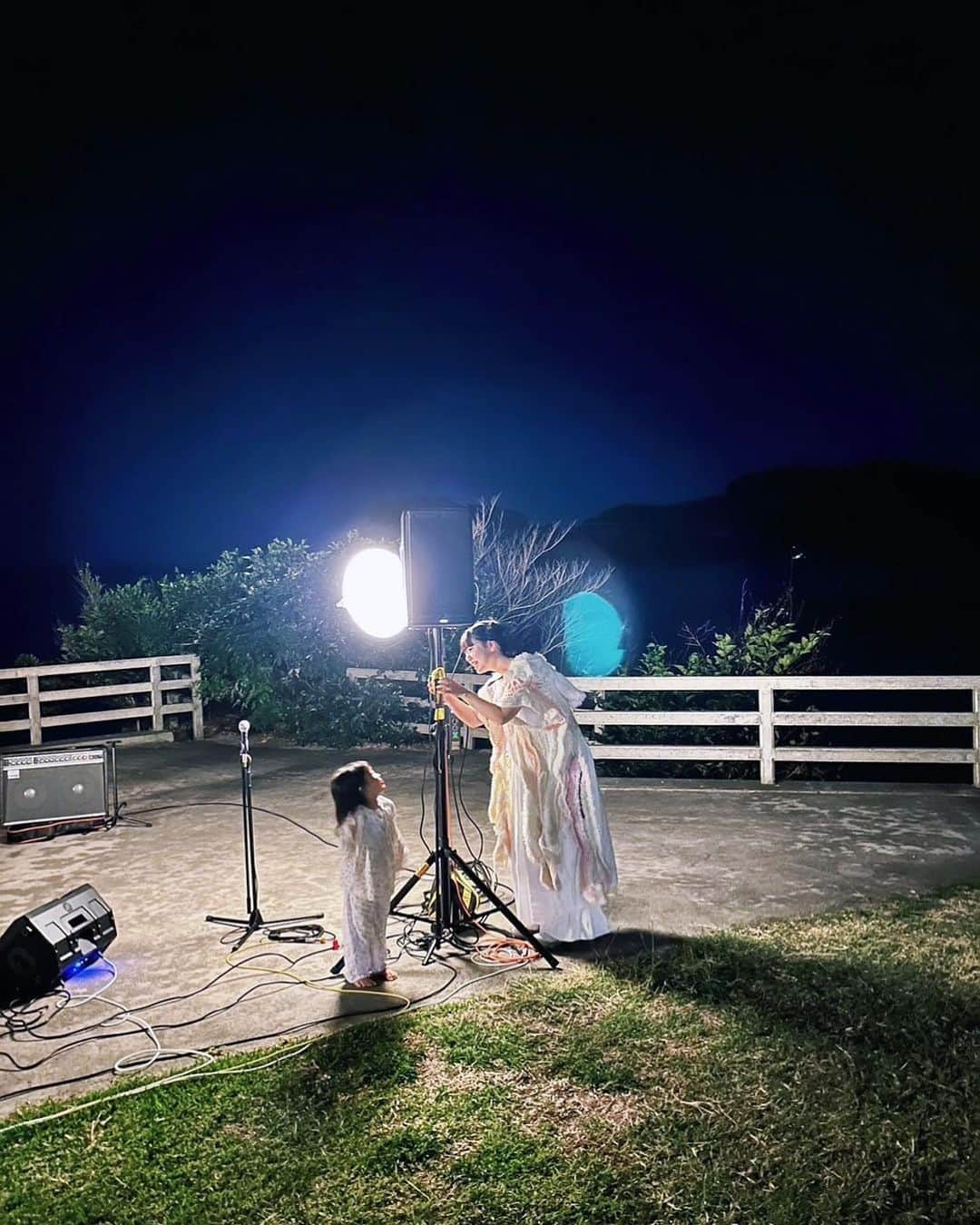 永原真夏のインスタグラム：「Musicalium Tour沖縄🌙  沖縄への旅のはじまりは、十数年前の「きみのうたをまってる」というタイトルのイベントからでした。 その言葉はその後ずっと、自分のライブの大きなテーマになっています。歌いながら、きみのうたを待っている。 初めて来沖した日、イベントタイトルにちなんで、共演した友人が歌を作ってステージで歌っていました。その歌は「きみのうたを待っている」からはじまり、そのあと「風に吹かれて待っている」と続きます。 もう何回目かもわからない、数えることもやめてしまったほど自分の一部となった沖縄ライブ。今年はアンコールのSUPER GOODを歌う前に、友達の子供がぴょこっと抱きついてきて、だっこしたまま歌いました。その子は曲中ずーっとわたしをぎゅっと抱きしめたまま、最後まで一緒にいてくれました。 きみのうたをまってる、風に吹かれて待っているの風の先は、星のきれいな宮城島。  満点の星を数えてみろよ、あの全てをスターって呼ぶんだぜ。大好きな友人の詩です。  コテージの窓を開けたまま眠りました。波の音と、友達の喋り声が少し遠くから聴こえる中で目を閉じると、胸がいっぱい。 昼前に目覚めると、昨夜が幻だったみたいにからっとした大きな海がありました。海は広いな大きいな。  大好きな場所。また来年ね、風の先で✧  写真 @dejane_rio  映像 サクラマコト 企画 @gshelter」