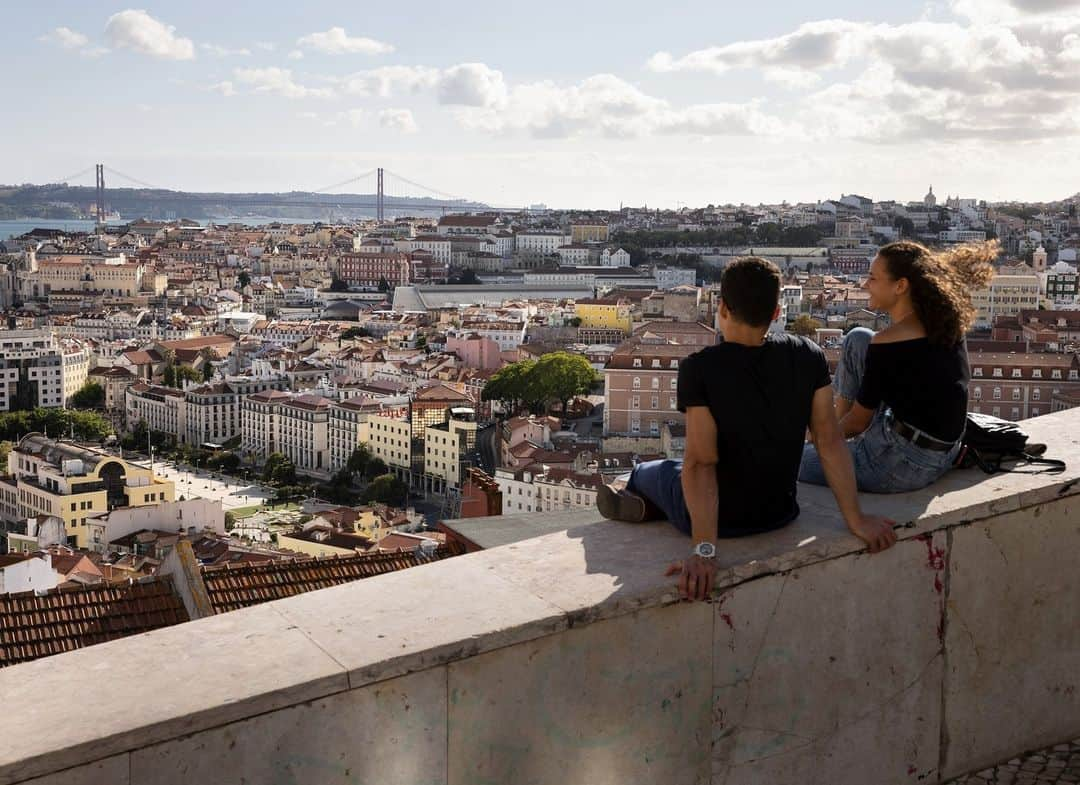 National Geographic Travelのインスタグラム：「Photo by @gabrielegalimbertiphoto | A couple enjoys a view of downtown Lisbon, Portugal.」