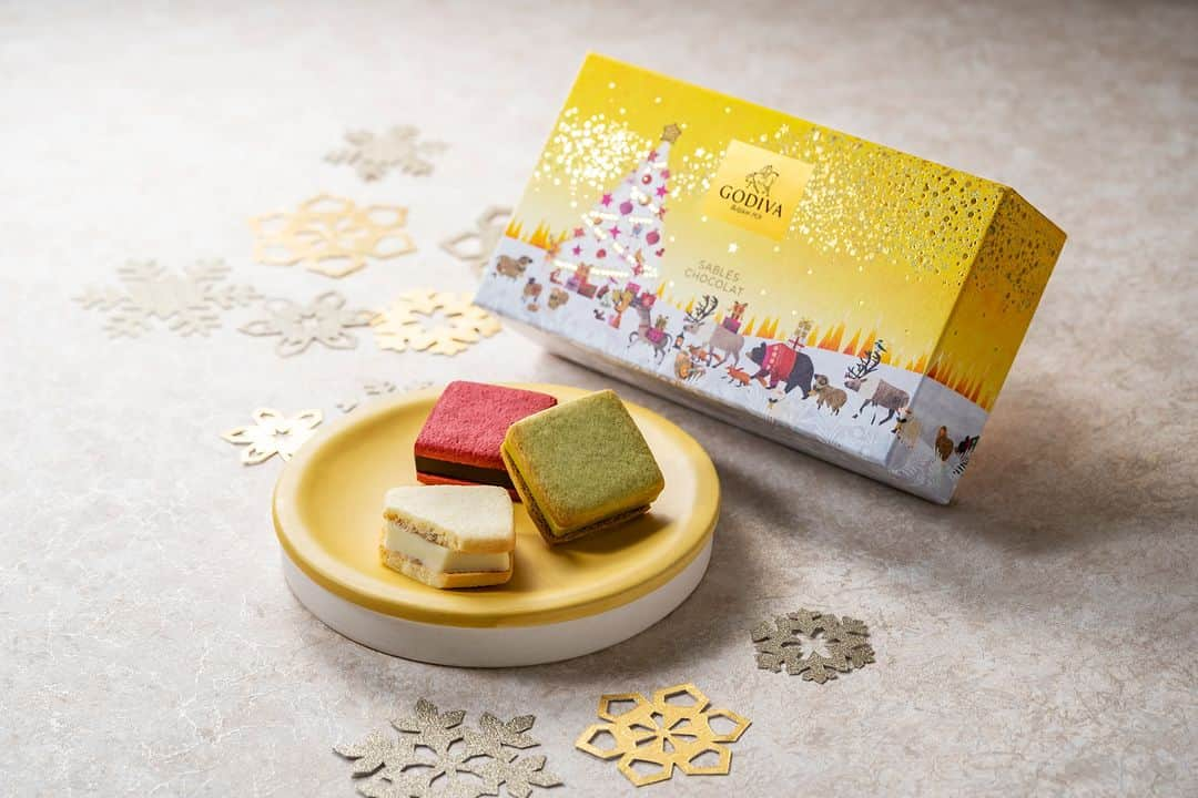 GODIVAのインスタグラム：「大好評販売中🎉ホリデー＆ニューイヤー限定 焼き菓子から「サブレショコラ」のご紹介🎅  カラフルで華やかなサブレショコラ✨ 限定フレーバーの「ニューヨークチーズケーキ」はベルギー産ホワイトチョコレートガナッシュに、 コク深いナチュラルクリームチーズが溶け込んだ豊かな味わいで、やさしい甘さが広がります🧡  パッケージには星降る夜空の下、深い森の中で動物たちが集ってクリスマスを祝う様子を描いており、 ホリデーコレクション「星降る森のクリスマス」のパッケージと連動した華やかな限定デザインに🎄  ホリデーシーズンの手土産にもおススメです！  ==【商品詳細】================================= ■「サブレショコラ」 ■販売期間：2023年11月1日（水）～ ■取扱店： 全国のゴディバショップ、GODIVA café、ゴディバ オンラインショップ ============================================== 詳細はプロフィール（@godiva_japan）より公式サイトにてご確認ください  #ゴディバ #GODIVA #クリスマス #サブレショコラ #クリスマスプレゼント #クリスマススイーツ #チョコレート好き」