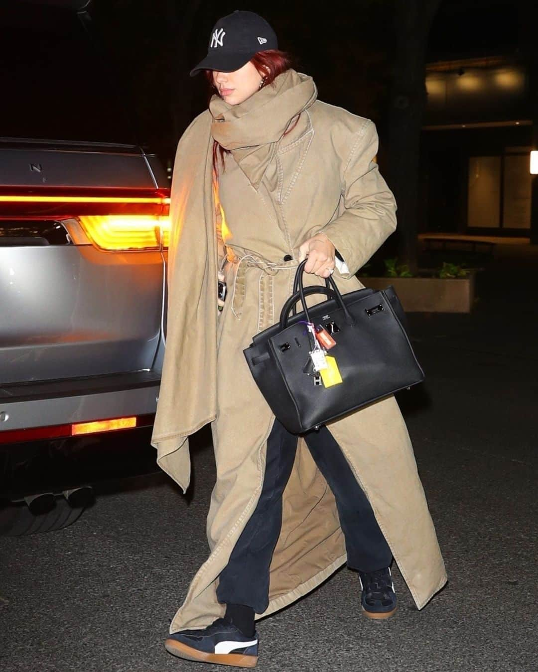 マリクレールのインスタグラム：「The look ➡️ the blueprint.  #DuaLipa doubled down on the exaggerated scarf trend (originated, of course, by *that* #LennyKravitz look), stepping out in an oversized khaki trench with an attached, extra-long scarf. Link in bio for all the details. photos: Backgrid」