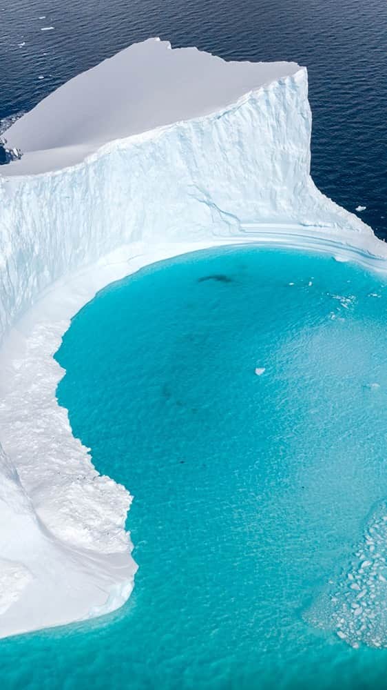 National Geographic Travelのインスタグラム：「Video by @daisygilardini | One of the most difficult things to achieve when photographing in Antarctica is bringing home images that convey the grandeur of the landscape and the size of the icebergs. When capturing images in the wilderness, we tend to exclude the human element—and so underestimate its importance. In this case the inclusion of the sailboat gives the viewer the right sense of scale.  Shot with permission from Environment and Climate Change Canada under the Antarctic Environmental Protection Act. Follow me @daisygilardini for more images and behind-the-scenes stories.」