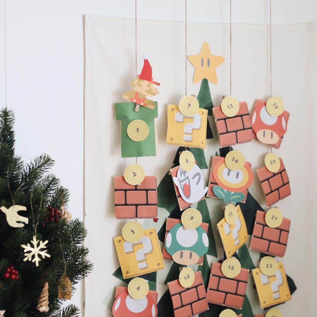 きなこのインスタグラム：「毎年恒例のアドベントカレンダー作り、今年はマリオに😊🎄  クリスマスプレゼントはマリオのゲーム（ルイージマンション👻）が欲しいらしいので、クリスマスまで気分が盛り上がってくれたらいいな😚  用意したマリオ素材を封筒にぺたぺた貼って、お菓子を入れて、吊るした麻紐にクリップで挟んで付けて作ってます♪  ツリーデザインのタペストリーを背景にしたら、ツリーの飾りみたい✨マリオツリー✨ 吊るさずかごにまとめて入れてるだけでも可愛かった🧺♡  作ってる様子、ブログにも載せてます🎅  #アドベントカレンダー #クリスマス #クリスマス準備 #マリオ #小学生 #小学生男子 #育児 #子育て #こどもと暮らす」