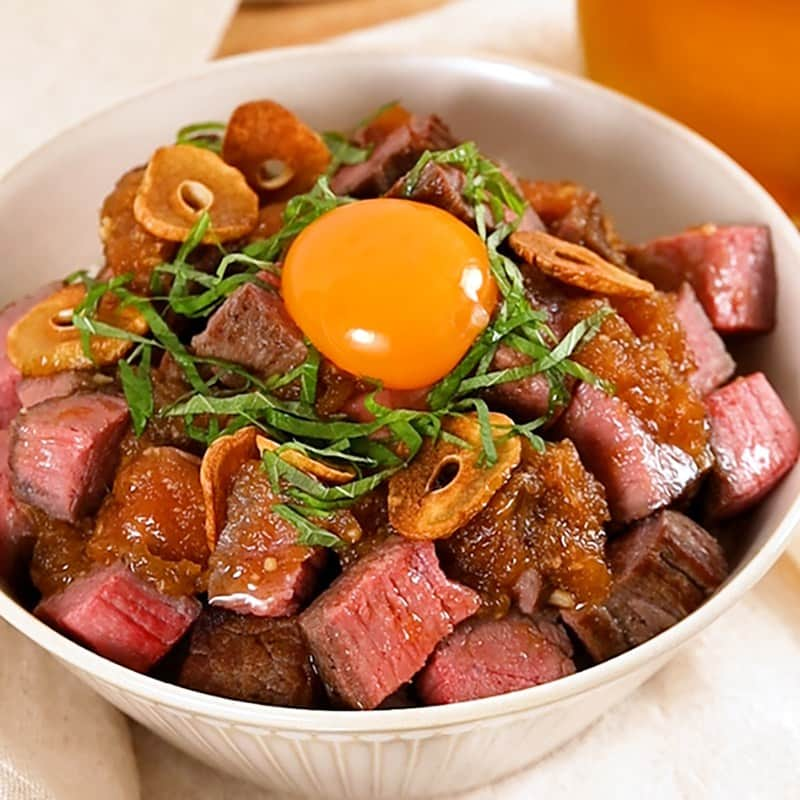 イオンのインスタグラム：「. 11月29日はいい肉の日🍖  今日は炊飯器で超簡単！な 『 お肉ごろごろ!ローストビーフ丼』のレシピをご紹介✨  ローストビーフは炊飯器を使えば簡単に作ることができます👩‍🍳 角切りにしたローストビーフを白米が見えないくらい山盛りにして召し上がれ♪  ⏰調理目安時間：15分 (保温時間を除く) ——————————————————————— 🍴材料 (2人前) タスマニアビーフ(モモ肉)【300g】 塩胡椒【適量】 お湯(70~80度)【適量】 オリーブオイル【適量】 にんにく【3片】 玉ねぎ【1/2個(120g)】 大葉【適量】 卵黄【1個】 [★] 酒【大さじ3】 [★] 酢【大さじ2】 [★] 醤油【大さじ3】 [★] りんごジュース【大さじ2】 [★] おろしにんにく【小さじ2】 [★] はちみつ【大さじ1.5】 ご飯【300g】 ———————————————————————   👩‍🍳レシピ ① にんにくは芯を取り、2,3mm幅に切っておく。玉ねぎはすりおろしておく。  ②牛肉は常温に戻して塩胡椒をする。  ③フライパンにオリーブオイルを引き、にんにくを香りが出るまで加熱し、一旦取り出す。  ④空いたフライパンで、牛肉の表面を強火で焼き上げ、アルミホイルに包んでビニール袋※に入れる。 💡POINT💡※耐熱性のあるビニール袋をお使いください。  ⑤お湯と共に炊飯器に入れ、50分ほど保温して、サイコロ状に切る。  ⑥空いたフライパンにすりおろした玉ねぎ、【A】を入れてソースを作る。  ⑦ご飯の上にローストビーフを乗せる。ソース、取り出したにんにく、大葉、卵黄を乗せて完成!  #イオン #aeon #トップバリュ #おうちごはん #おうちご飯 #おうちごはんlover #おうちごはんラバー #手作りごはん #おうちランチ #おうちカフェ #デリスタグラム #食べスタグラム #クッキングラム #料理 #手作り料理 #家庭料理 #おうち料理 #レシピ #簡単レシピ  #いい肉の日 #ローストビーフ #手作りローストビーフ #ローストビーフ手作り #ローストビーフ丼 #肉料理 #肉好きな人と繋がりたい #肉好きと繋がりたい #丼レシピ #丼ぶり #丼スタグラム」