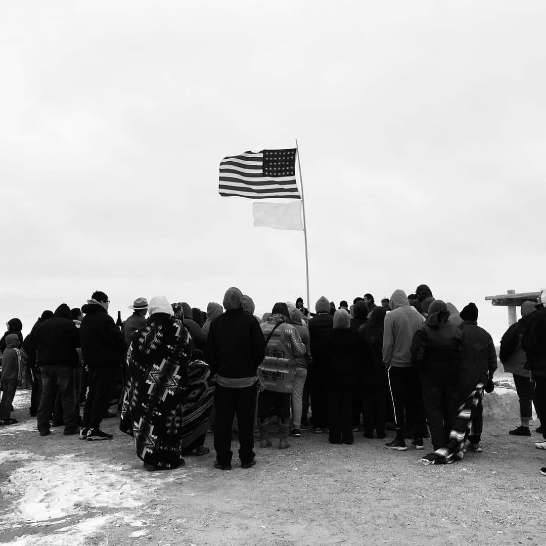 アメリカ内務省のインスタグラム：「The Interior Department is committed to telling America's accurate, authentic and complete history — even the difficult parts. Some of it hurts and some of it heals, but acknowledging our past can help us build a better future.    Chaotic, horrific, tumultuous and bloody, the events of November 29, 1864, changed the course of history. Sand Creek Massacre National Historic Site commemorates the brutal attack on a village of about 750 Cheyenne and Arapaho people along Sand Creek in Colorado.    The pain of the Sand Creek Massacre is felt by generations of Indigenous people. The site remains a sacred place to honor the dead and the dispossessed — a place where they are not forgotten.   Photos by NPS    Alt Text:    Photo 1: Members of the Arapaho and Cheyenne gathered around a 33 Star American Flag and a white flag during the Tribes' annual Healing Run.     Photo 2: Lodge (Tipi) poles, arranged without the hide covering, are set up in the creek bed of the Big Sandy Creek, near where the Cheyenne and Arapaho people were encamped when the Sand Creek Massacre happened.」