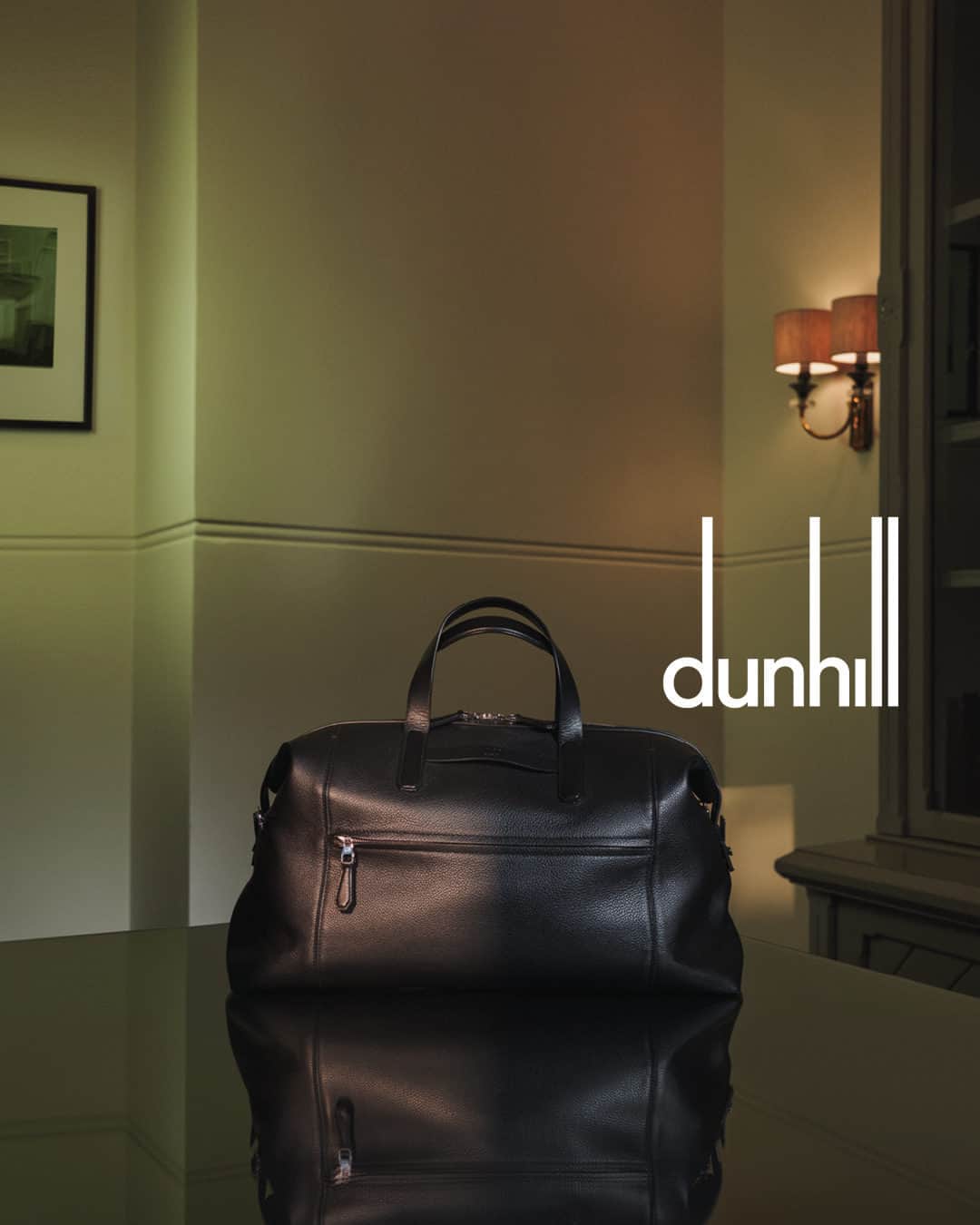 ダンヒルのインスタグラム：「Discover festive gifts that tell a story in-store and online at dunhill.com  Crafted from the finest black pebble-grain leather, dunhill’s 1893 Harness Holdall features top handles as well as a detachable leather shoulder strap, and a plethora of pockets both inside and out.  Photographed by @thurstanredding and styled by @stuartvwilliamson.   Discover the complete 1893 Harness leather goods collection.」